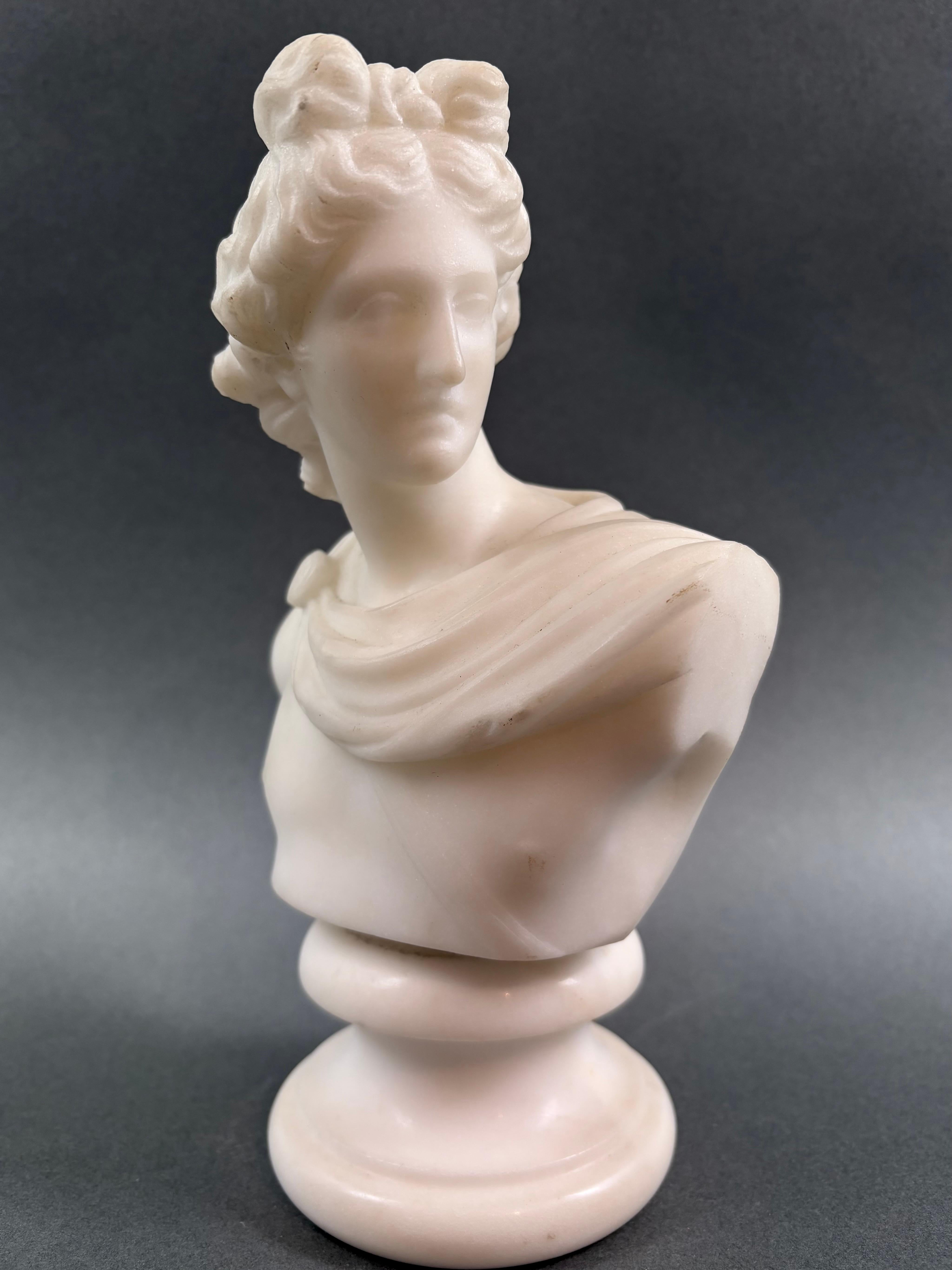 Piccolo busto neoclassico in marmo bianco di Carrara raffigurante l'Apollo del Belvedere. Bottega romana, metà del XIX secolo. I
 busti di piccole dimensioni raffiguranti capolavori antichi appartengono a quella produzione ispirata dal cosiddetto