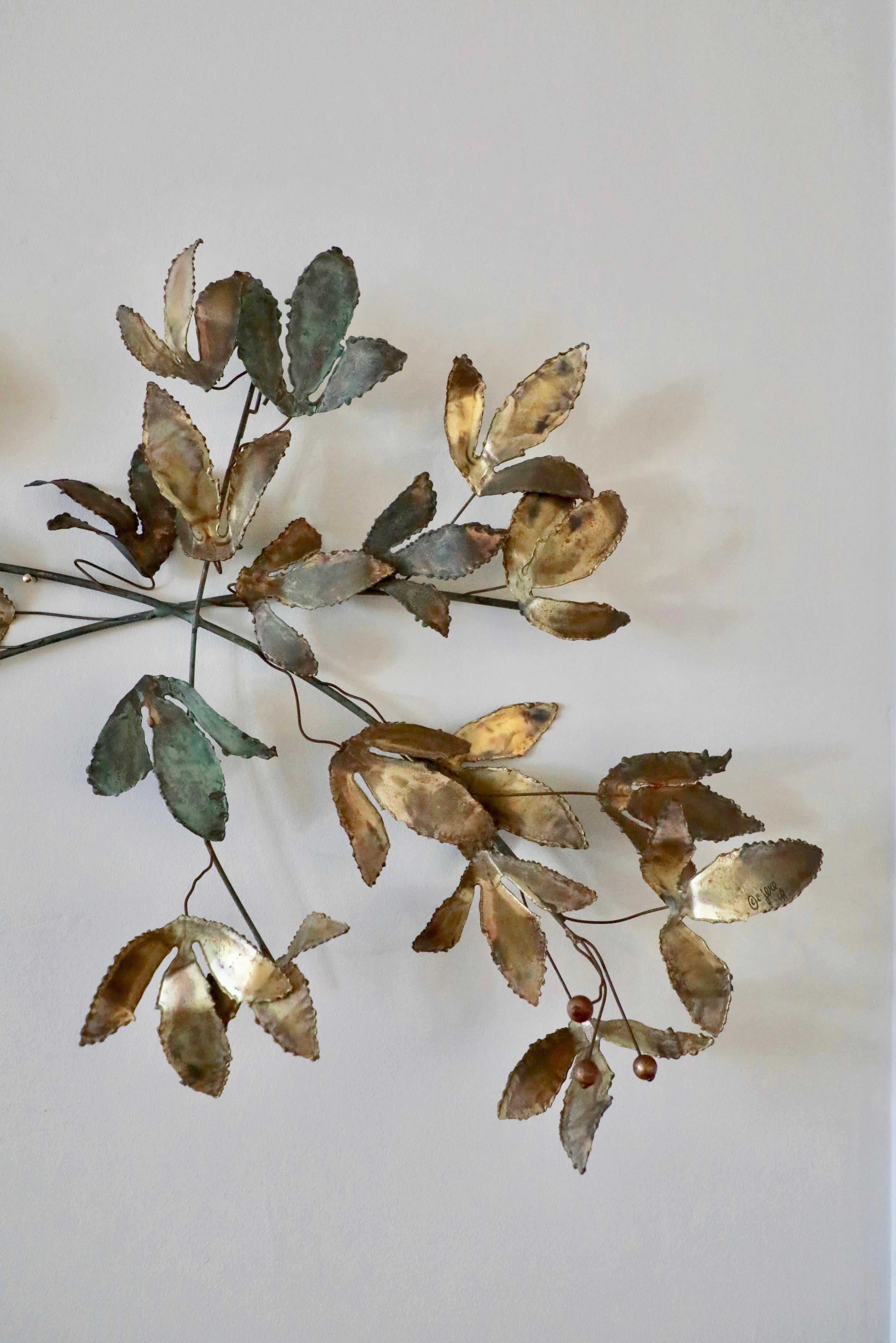 This is an especially beautiful mixed metal wall sculpture designed by C.Jeré and manufactured by Artisan House in California in 1969.  This design is an early, iconic one and makes a nice alternative to a painting.  The metal leaves reflect the