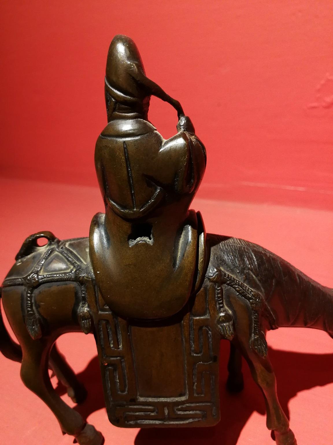 Petit bronze à brûler des senteurs du 18ème siècle représentant un homme chinois chevauchant la selle d'un âne. 