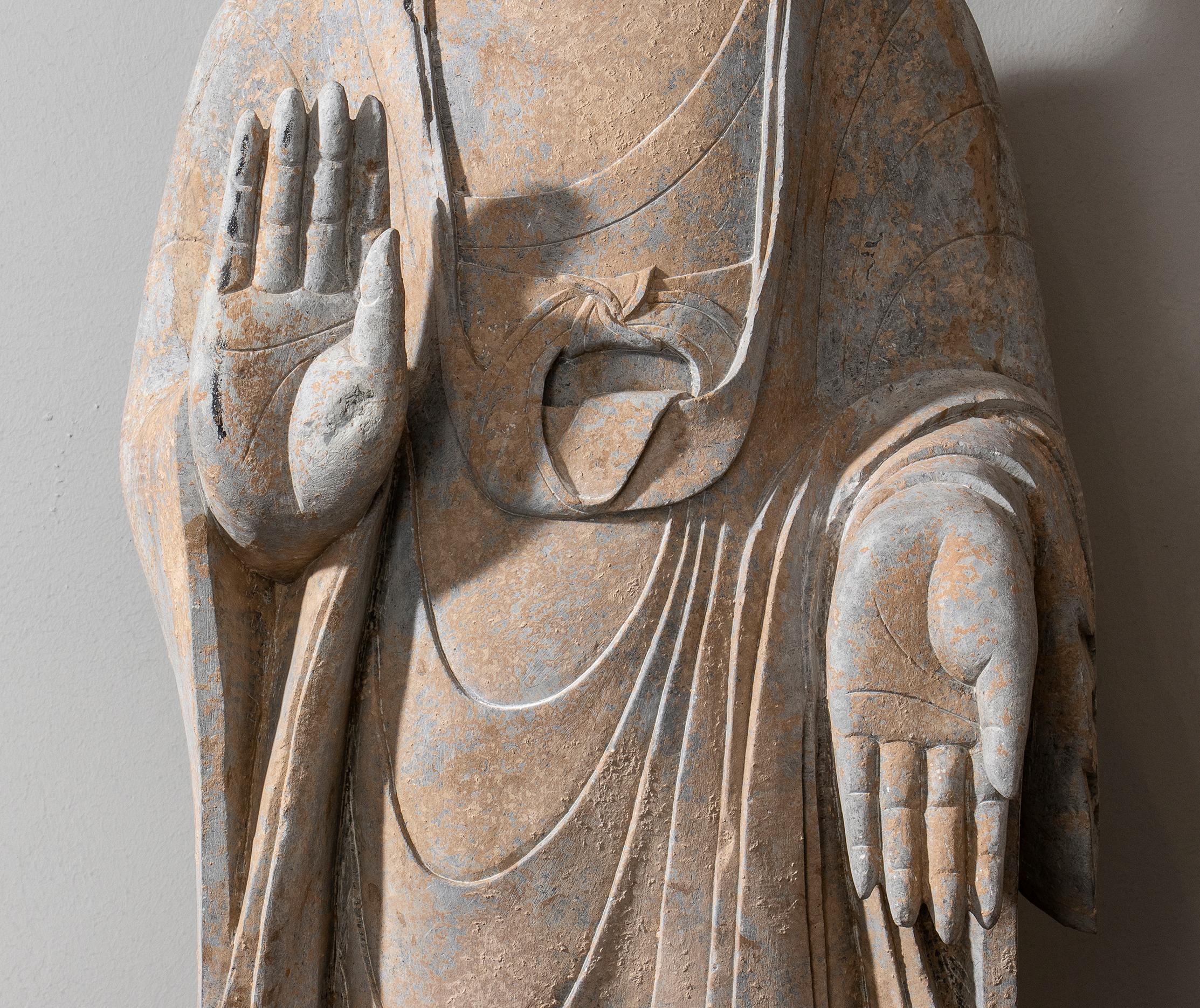 Une impressionnante sculpture en pierre de Bouddha dans le style des dynasties Tang et Wei, sculptée à la main. La figure de Bhudda, en mudra Abhayamudrā sculpté en position debout comme un professeur avec les deux mains la main droite orientée vers