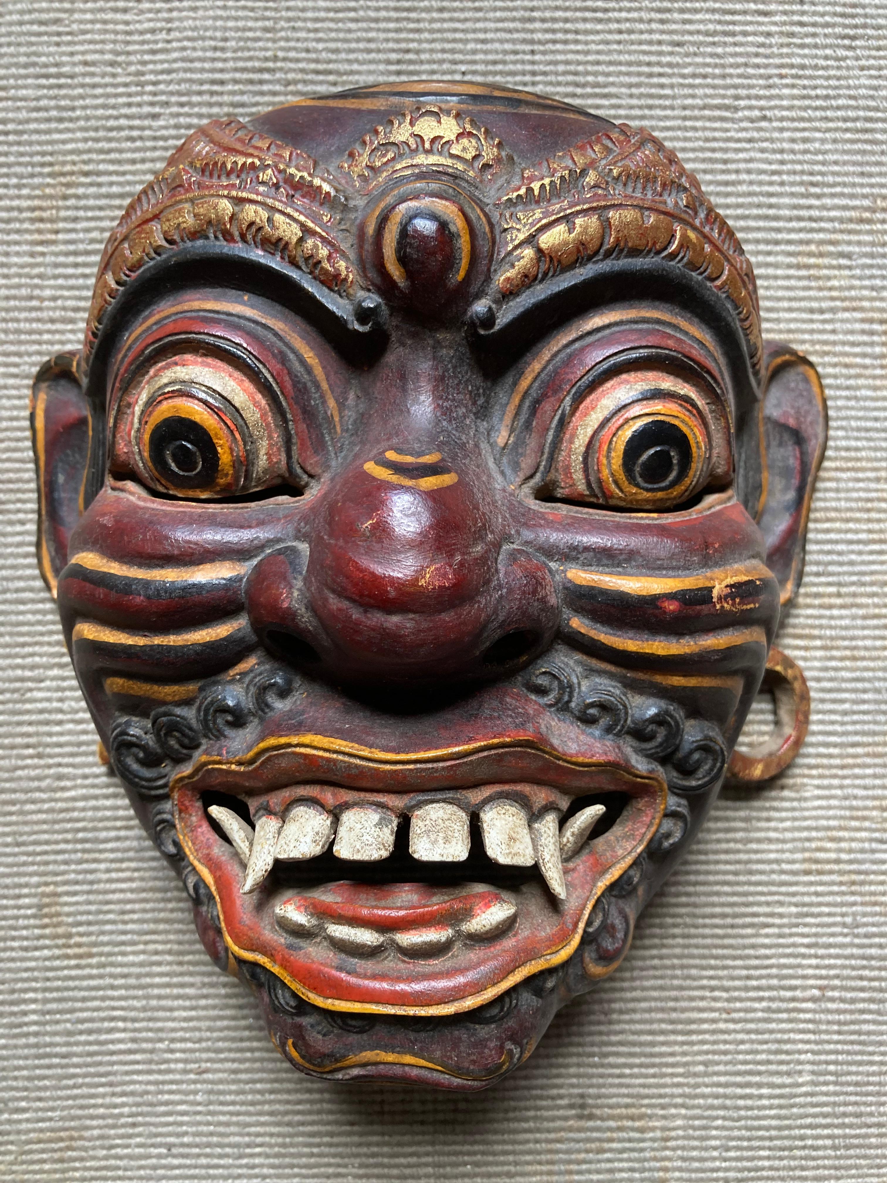 Eine Sammlung von fünf handgefertigten japanischen Noh-Drama-Masken, vier davon aus handgeschnitztem Holz und eine (die größte, die auf der einen Hälfte schwarz-rot und auf der anderen weiß ist) aus Pappmaché. Der größte ist 15