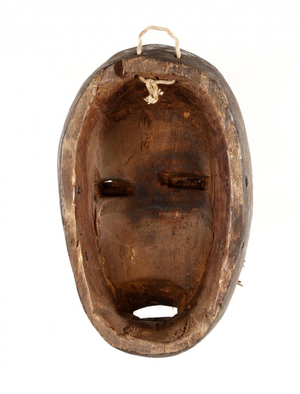 Rare masque d'art africain en bois sculpté provenant de la Côte d'Ivoire ou du Libéria au 20ème siècle.
Ce masque est sculpté en bois, représentant un visage féminin en bois sculpté peint et dans des tons de rouge, avec des applications de tissu et