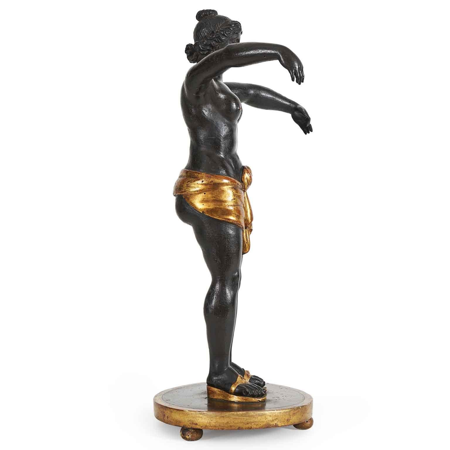 Circe 19th-century Italian Wooden Sculpture, the proposed neoclassical figure is a fascinating and rare depiction of the Goddess Circe, made in the early 1800s. The pine wood carving and ebonizing technique with golden details add value and