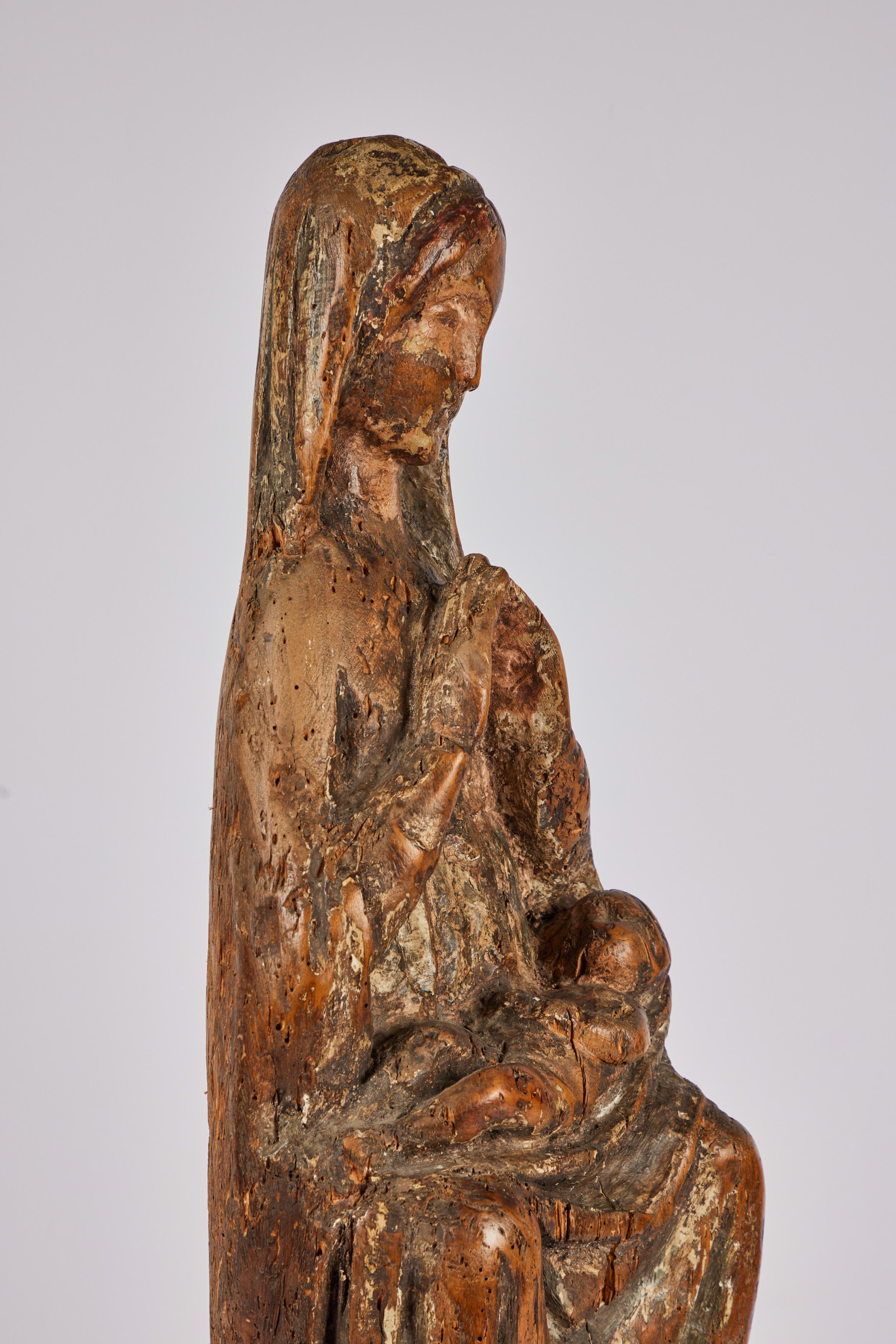 An evocative, 14th century, carved wood statue of a seated Mary with the Christ child in her lap. The piece with a beautiful patina featuring polychrome paint traces. Now mounted on a contemporary, stepped Lucite base.

Mounted: 31.25