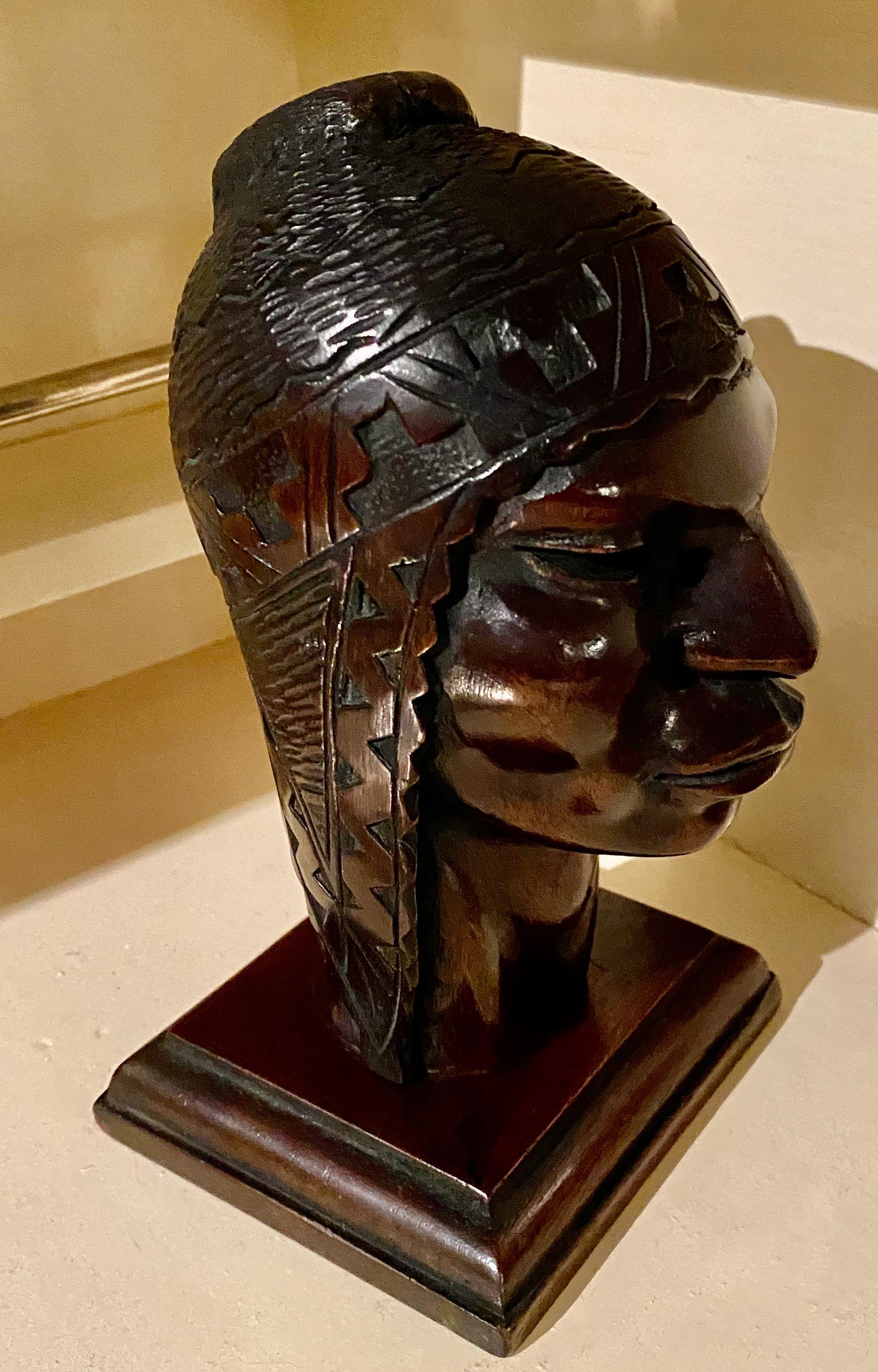 Tête originale d'Indien péruvien sculptée en bois dans le style Art déco. De nombreux détails géométriques et triangulaires sont intégrés à la coiffe. Selon une histoire intéressante, les caractéristiques du visage semblent provenir d'une origine