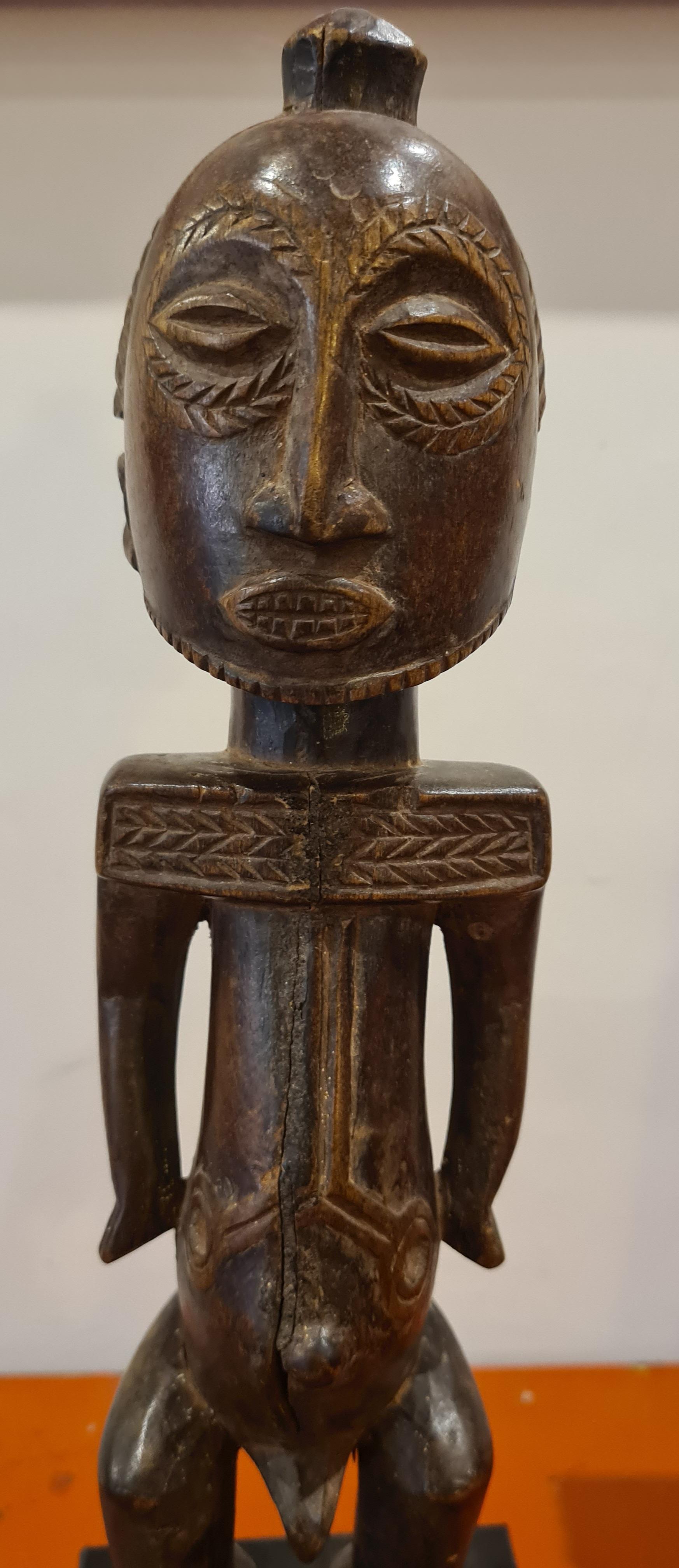 Eine aus Holz geschnitzte männliche Stammesfigur aus der Mitte des 20. Jahrhunderts, Luba Hamba.

Stehend, die Arme frei vom Körper und die Hände seitlich vom Bauch, die Rundfrisur mit erhabenem 