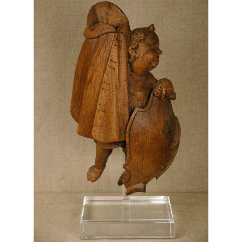 Hand-carved, oak statue of a putto holding a flowing tapestry and a shield mounted on a custom, Lucite base.