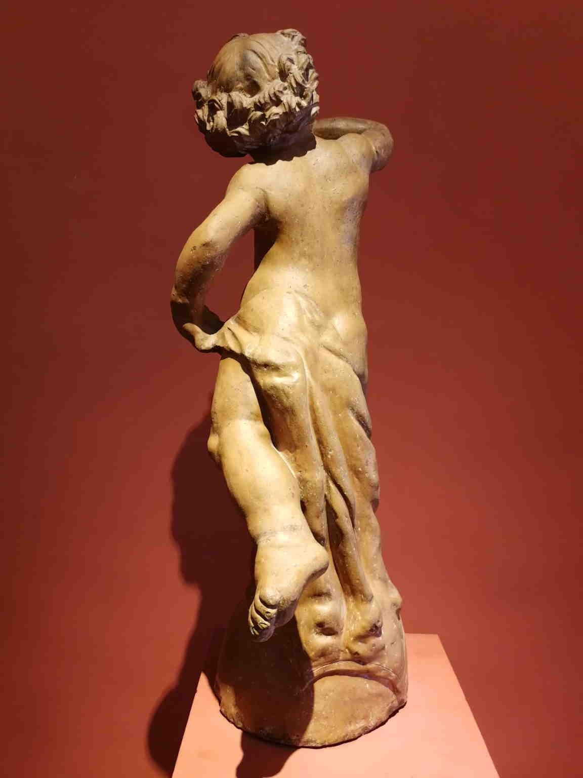 Terrakottastatue, die einen Putto darstellt, der mit einem Tuch um sein Bein bläst. Es ist inspiriert von dem Putto mit Delphin von Andrea del Verrocchio, der für einen Brunnen im Palazzo Vecchio (Florenz) geschaffen wurde. In Anbetracht des