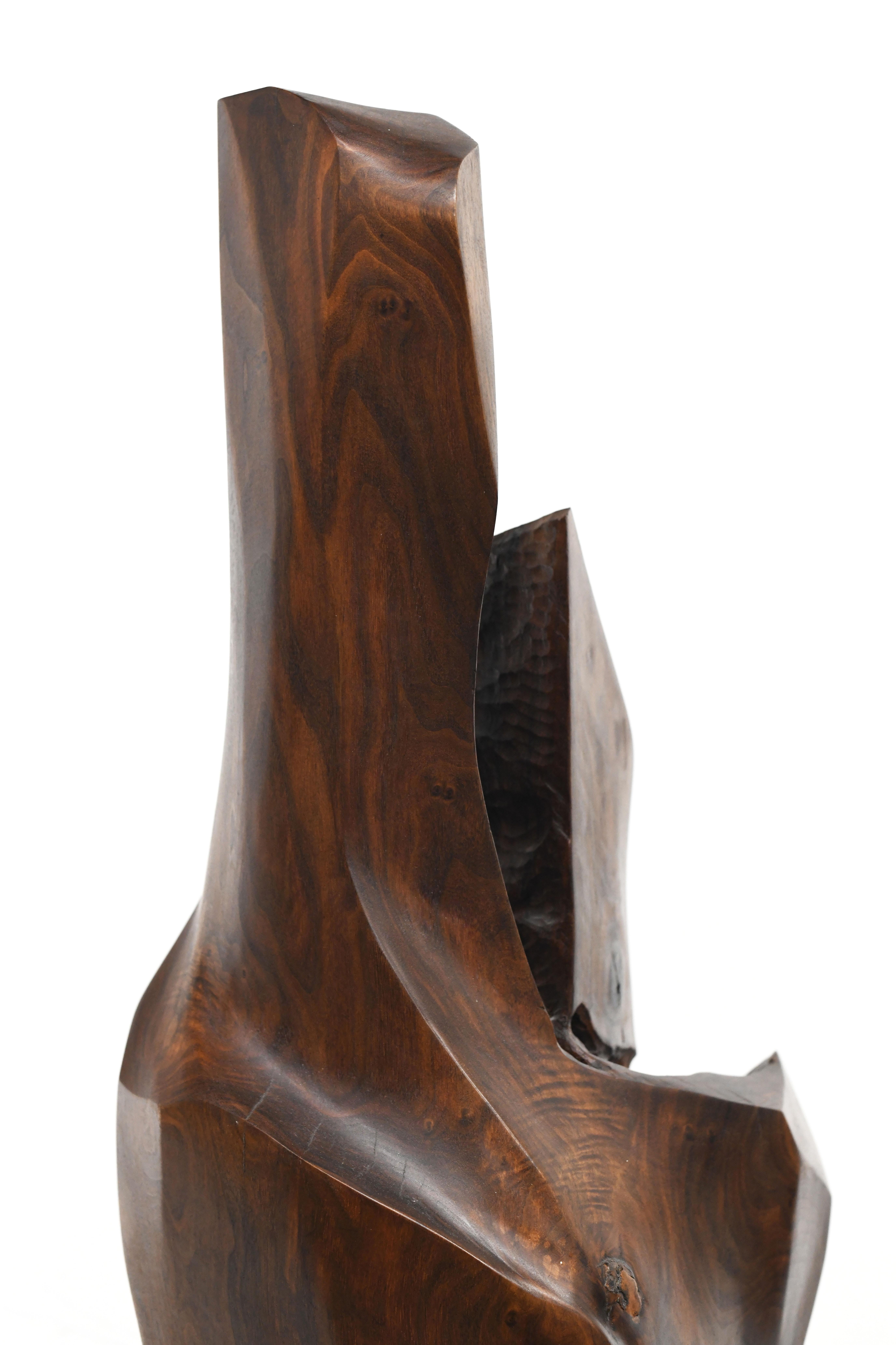 Exceptional wood sculpture carved from a single piece of solid black walnut. Sculpture is signed D. Gibbins and dated 1986. Wood pedestal is included. Condition is excellent. Measures 64 inches high without pedestal.


