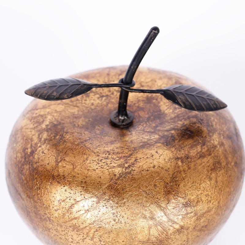 Large sculptural apple crafted in porcelain and decorated with textured gold leaf with metal leaves.