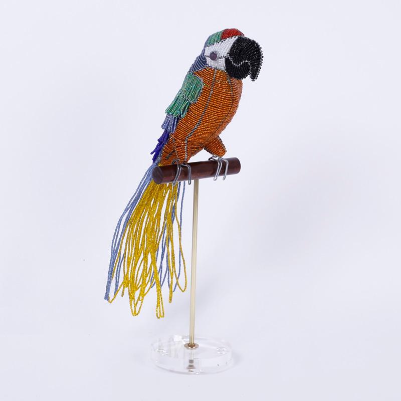 Glass beaded parrot sculpture ambitiously crafted with glass beads and perched on a custom wood, brass, and Lucite stand.