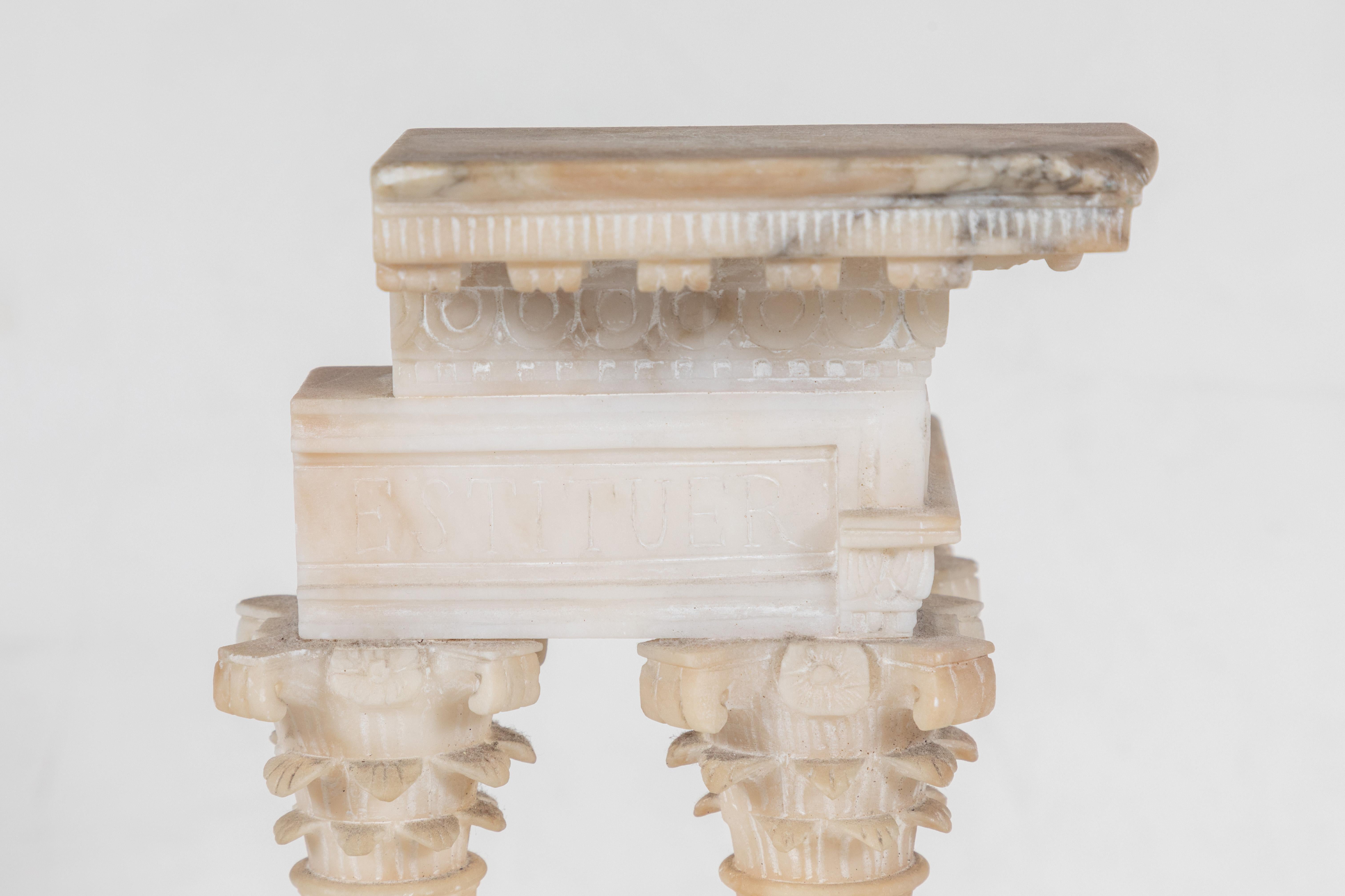 Beautifully carved, Grand Tour period architectural model featuring fluted columns surmounted by Corinthian capitals and a relief carved pediment above a raised  base inset with a flight of steps.  All resting on a marble base.