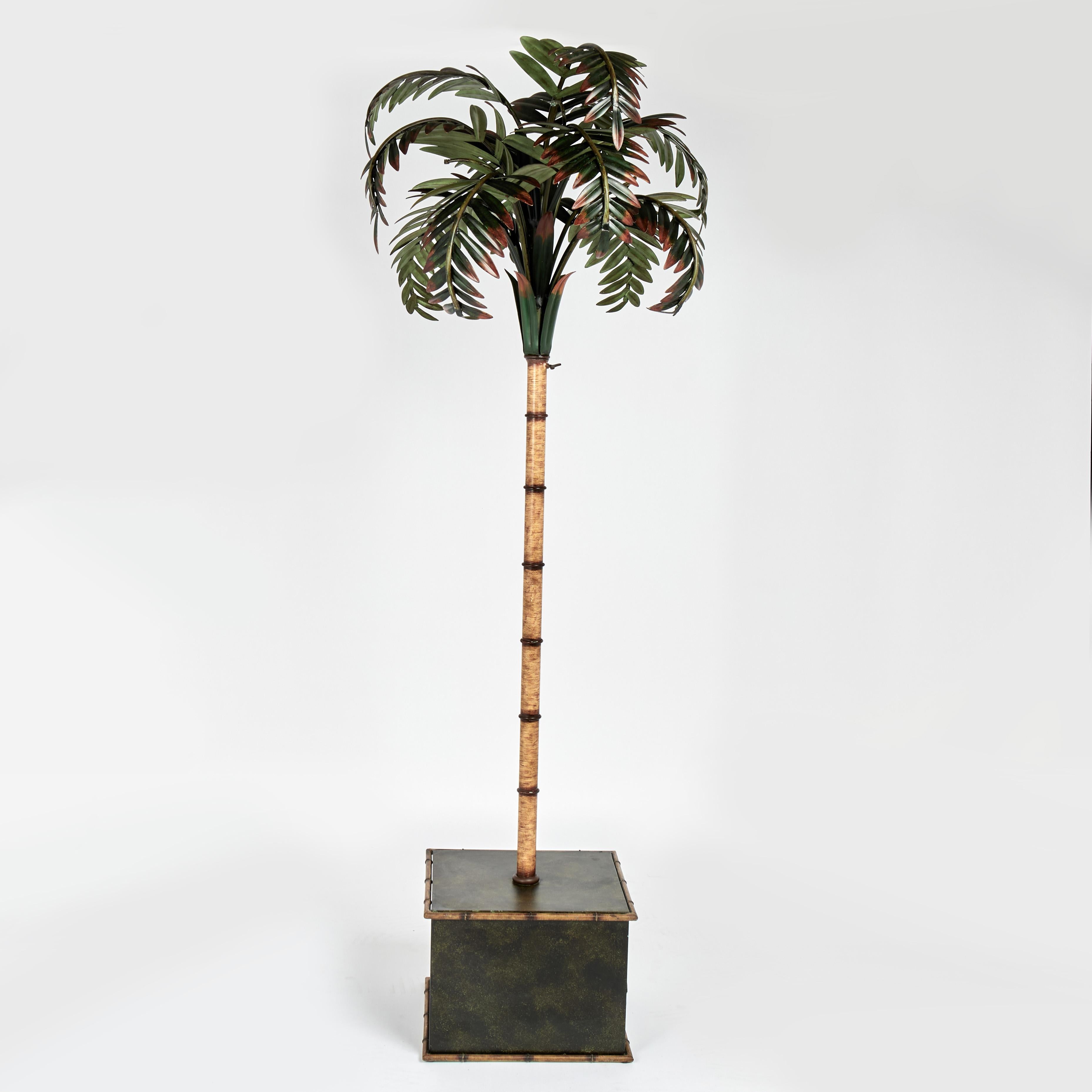 Group of three mid century tole palm tree sculptures crafted in metal in a chic stylized modern form with painted leaves and faux bamboo trunks set in classic square bases with faux bamboo highlights. Each break down in three parts.

Left H: 75 DM: