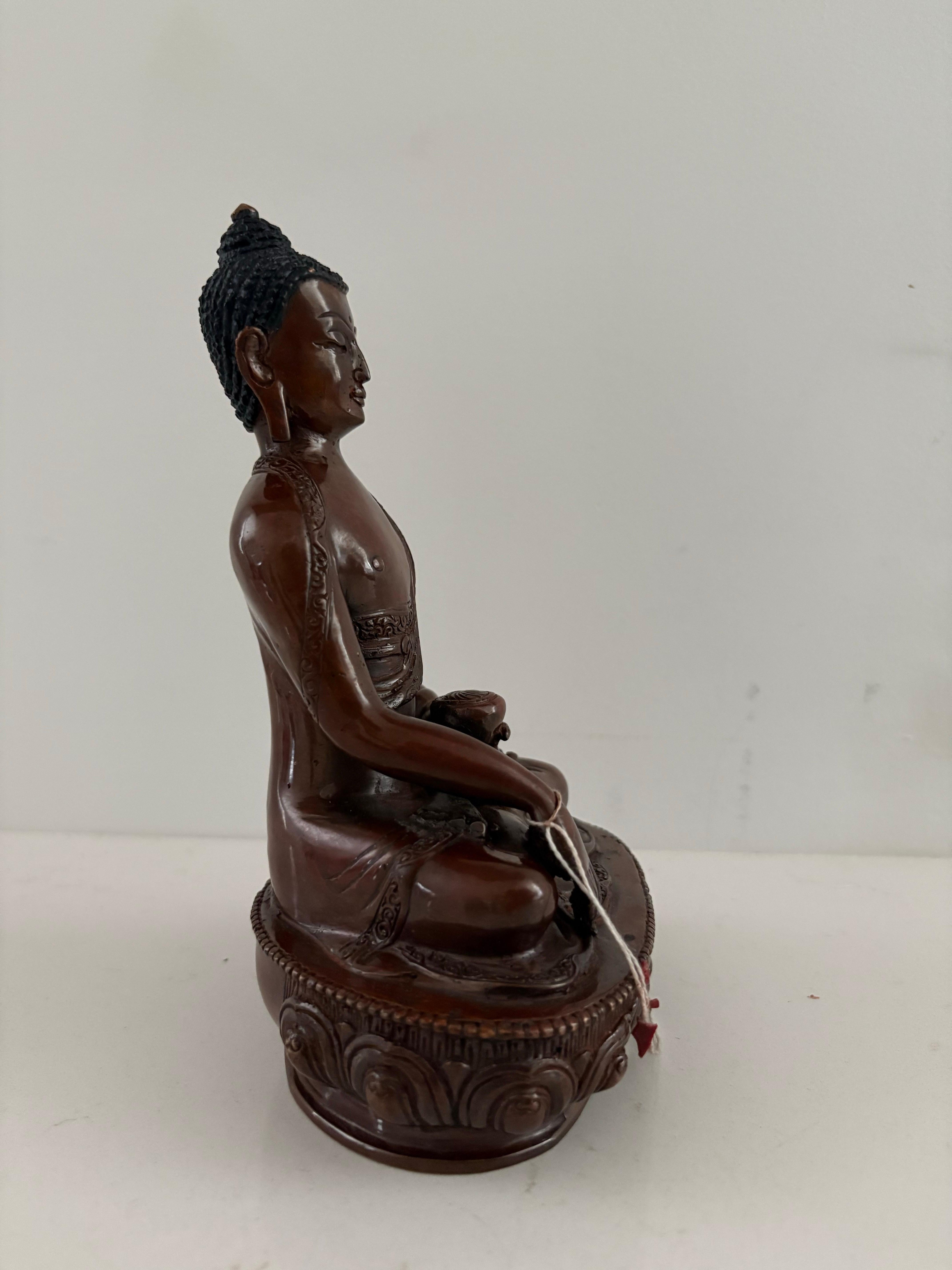 This 7.5-inch tall Buddha statue is a fine example of traditional Nepalese craftsmanship, meticulously handcrafted by artisans of Patan, Nepal using the ancient lost-wax process, a method passed down for centuries. Cast in solid copper, the statue