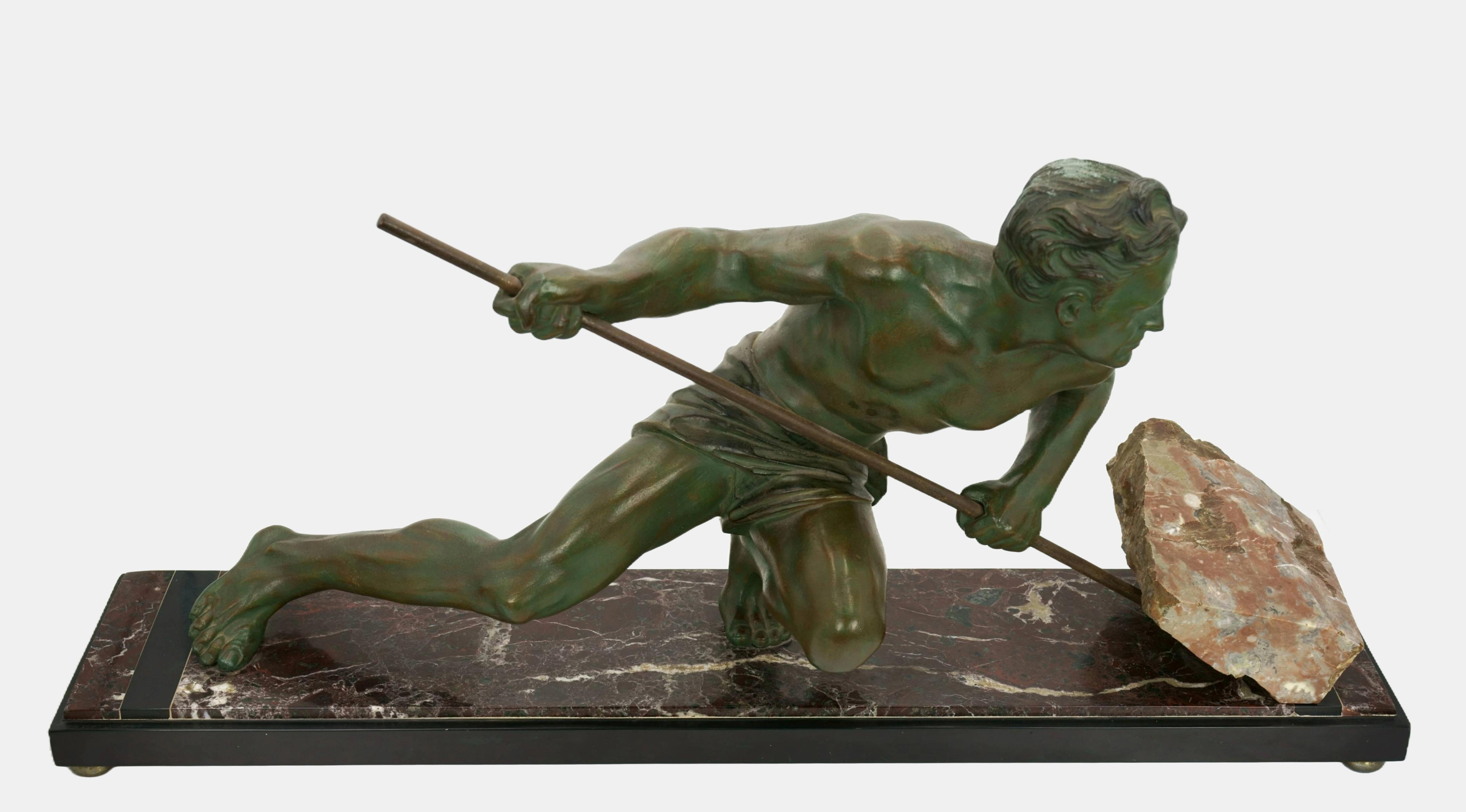 Anónimo, Trabajador heroico levantando un canto rodado, c. 1930. Fundición de zinc patinado verde con piedra natural montada sobre una base de mármol rojizo. Dimensiones de la base: 4,5 cm (altura) x 74,5 cm (longitud) x 20 cm (profundidad).