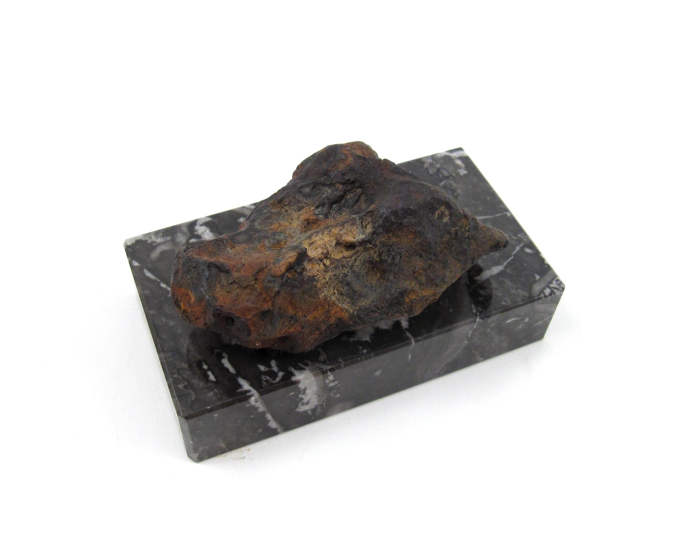 A Natural Iron Sculpture Shaped by Nature

The sculptured Meteorite is presented on a polished, black and white flamed marble block and held in place by a strong magnet. The specimen can be removed or positioned according to the liking of the