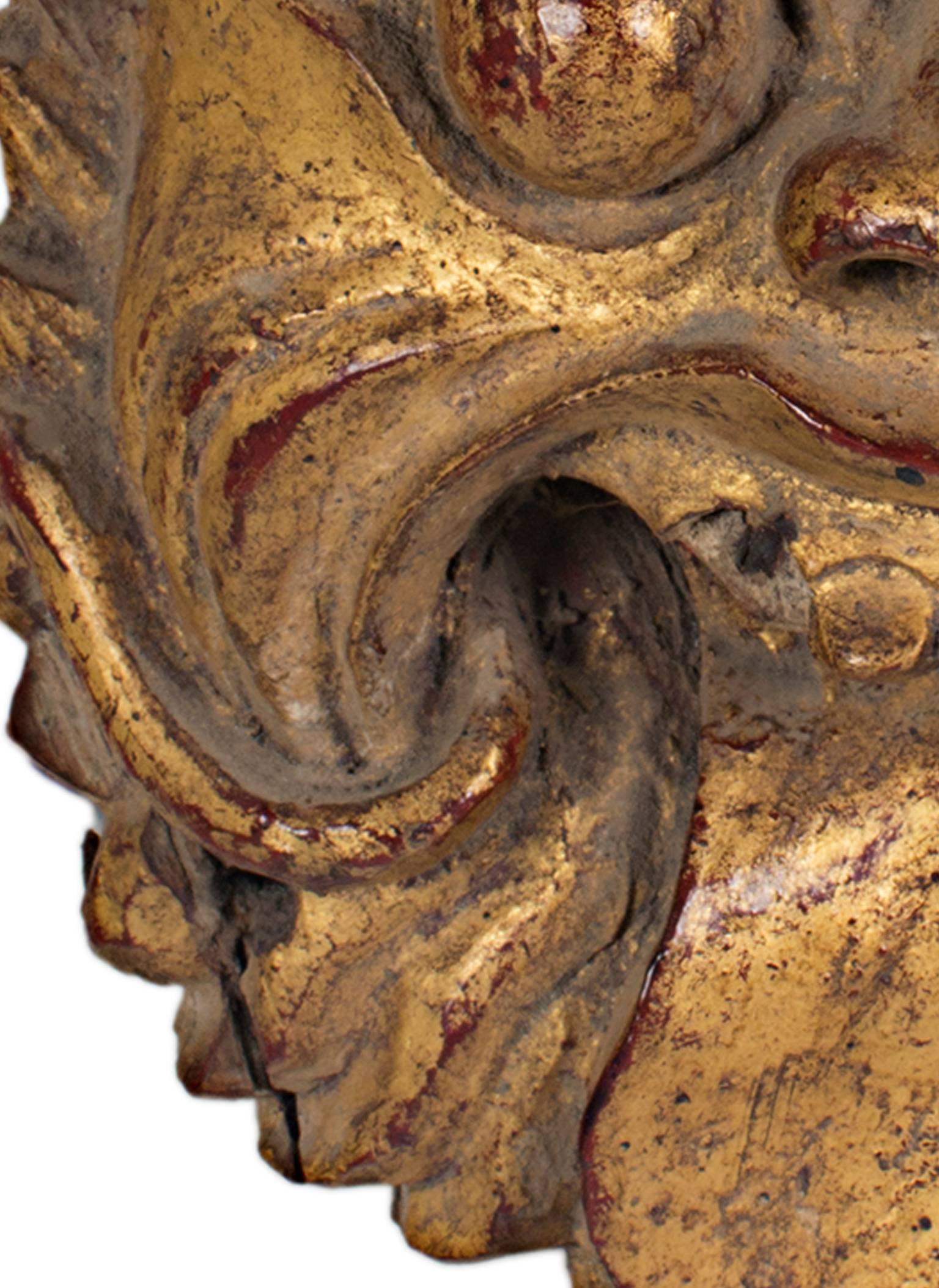 Ce masque a été réalisé par une sculpture indonésienne inconnue. Il est sculpté dans le bois et recouvert de feuilles d'or. Il présente un visage abstrait et mesure 7