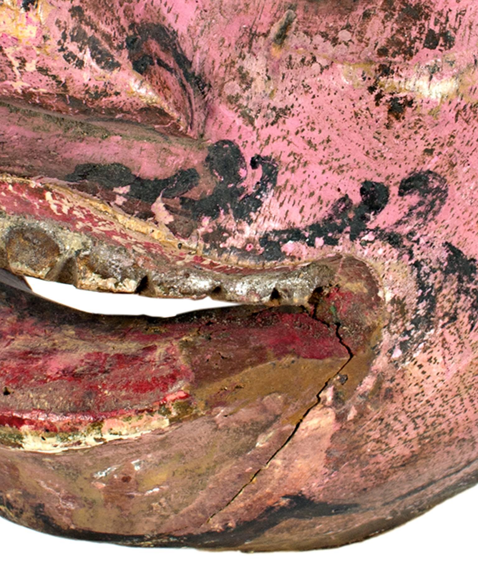 Questa maschera in legno, con pelle rosa e occhi rotondi, è stata realizzata da un artista indonesiano sconosciuto. Questo pezzo misura 7,5 pollici di altezza per 4,5 di larghezza.