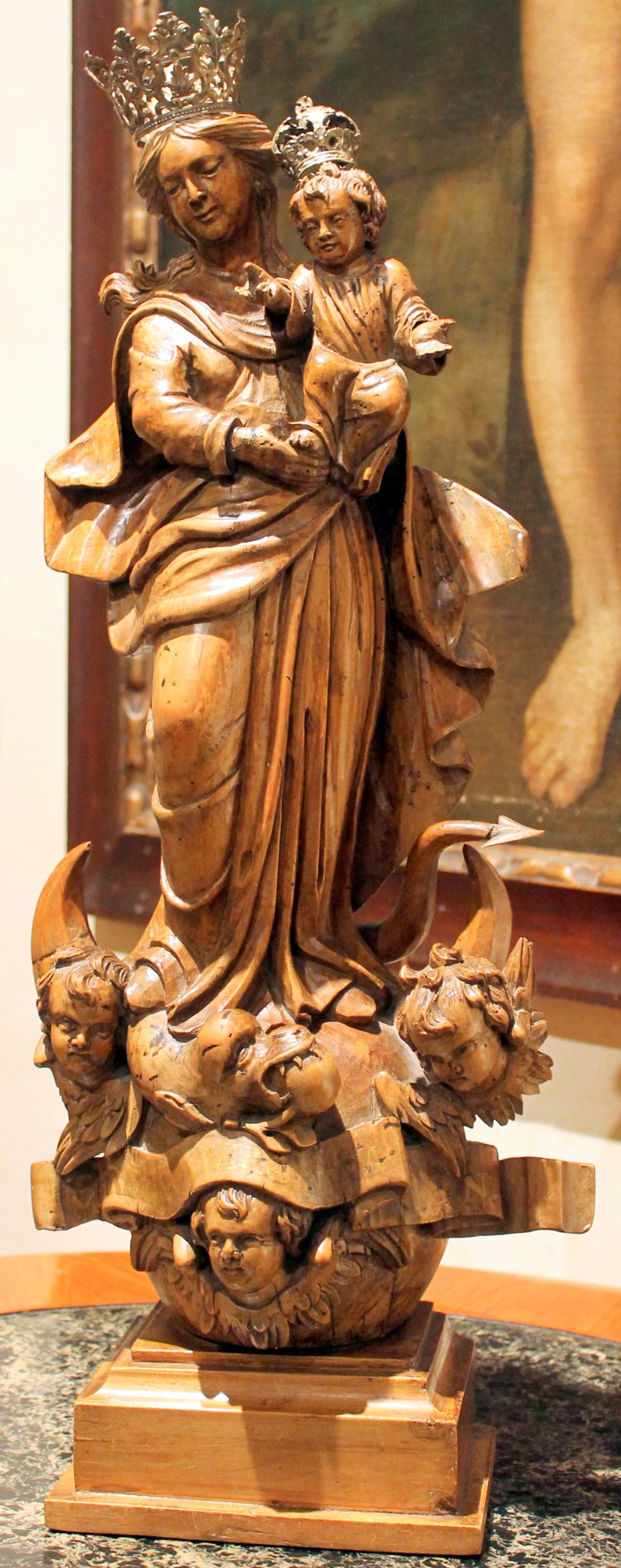 Extremely representative Northern Italian school hand carved wooden sculpture from early 18th century featuring a serene Madonna with child standing above the terrestrial globe and crescent moon.
This solid lime wood sculpture of a crowned Virgin