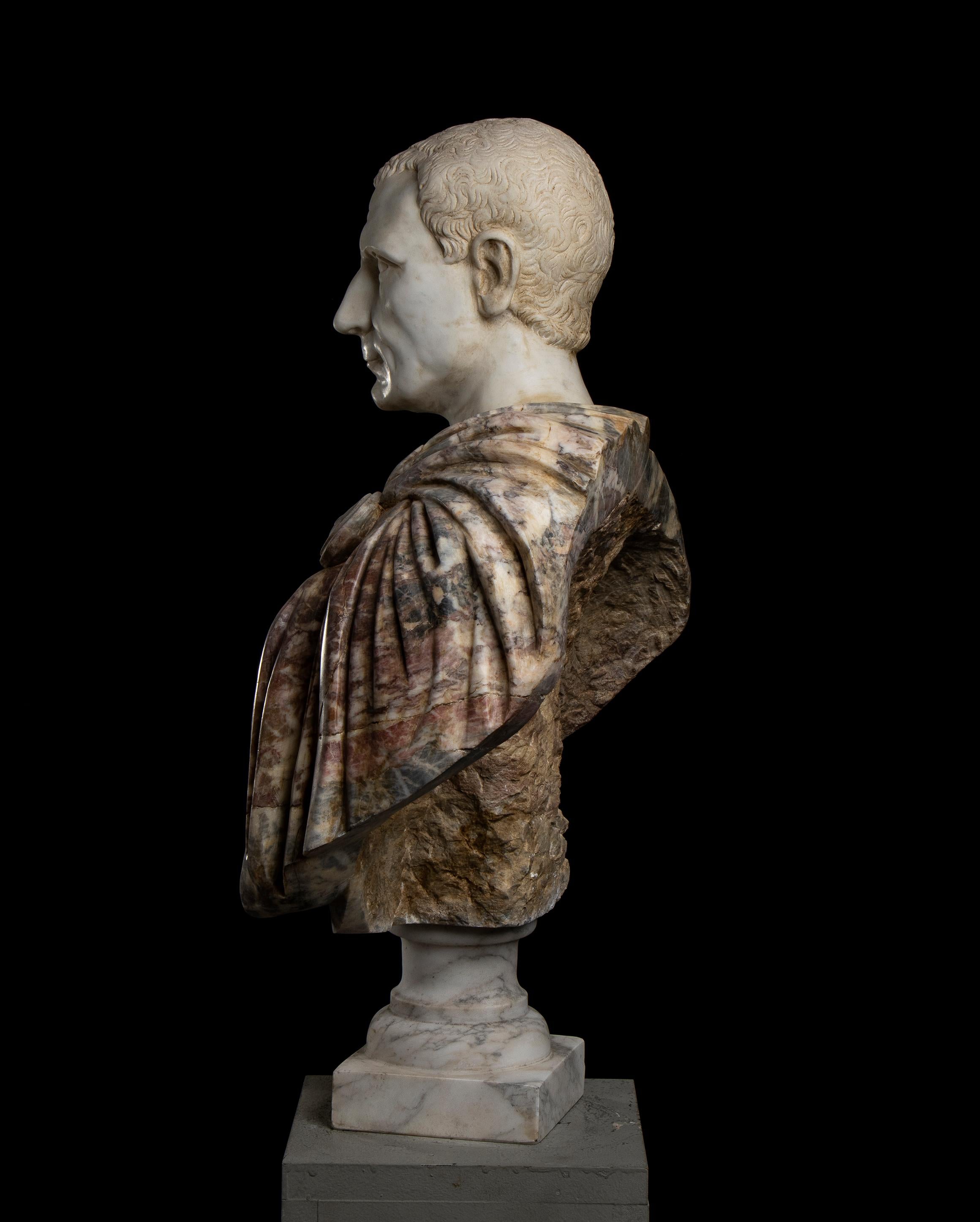 Importante escultura busto retrato de Julio César esculpida en mármol policromado según la tradición clásica romana; la cabeza refleja un pertinente retrato de Julio César según la iconografía clásica romana esculpida  en mármol blanco estatuario de