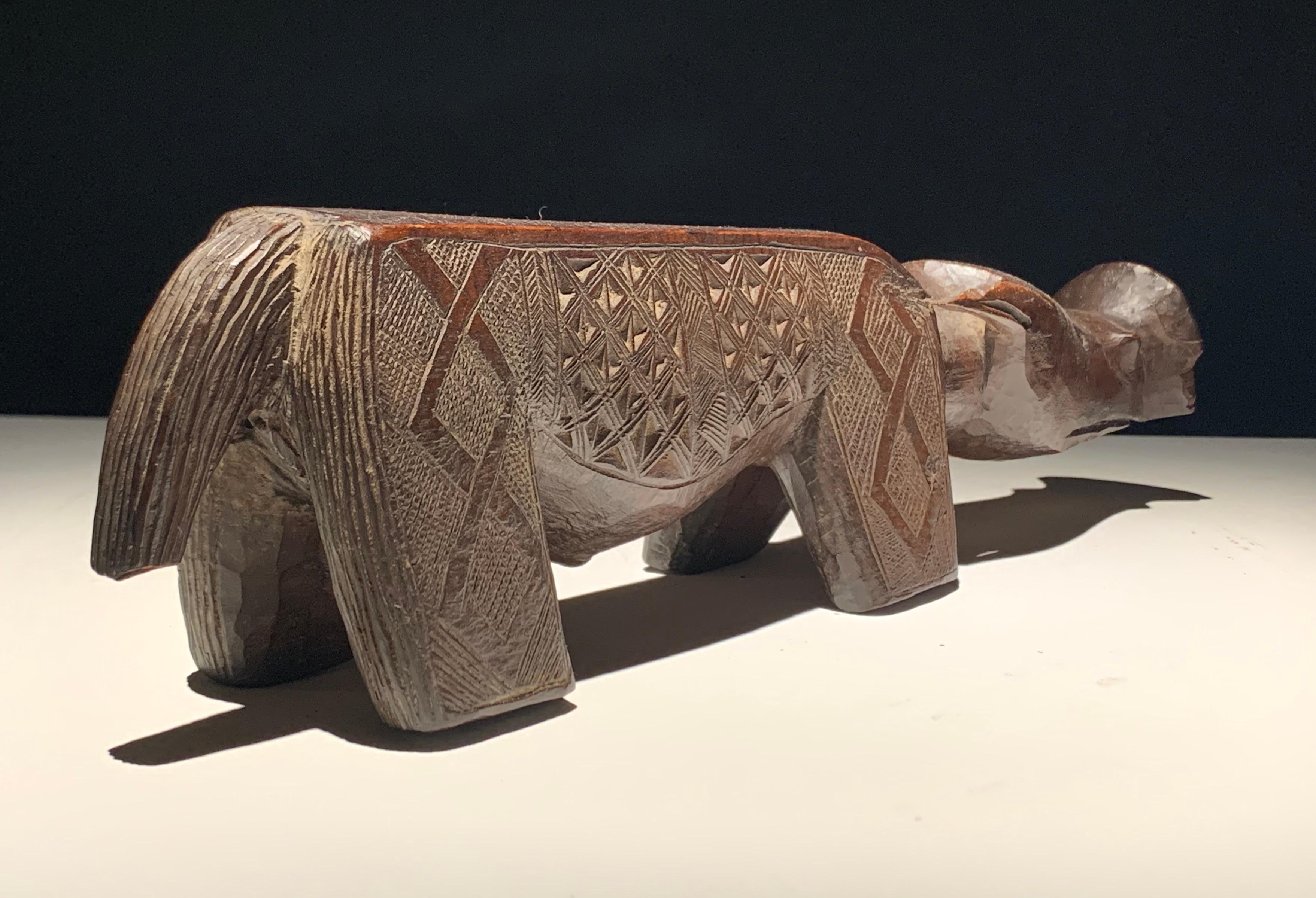 Warthog Divining Figure. Kuba, DRC. Late 19th century. Carved wood with palm oil patina, 12.5 incehes (l), 3.25 inches (h), 2 5/8 inches (d). Loss evident at tip of right ear and on snout. 

Provenance: Ex. collection Martin and Faith-Dorian Wright;