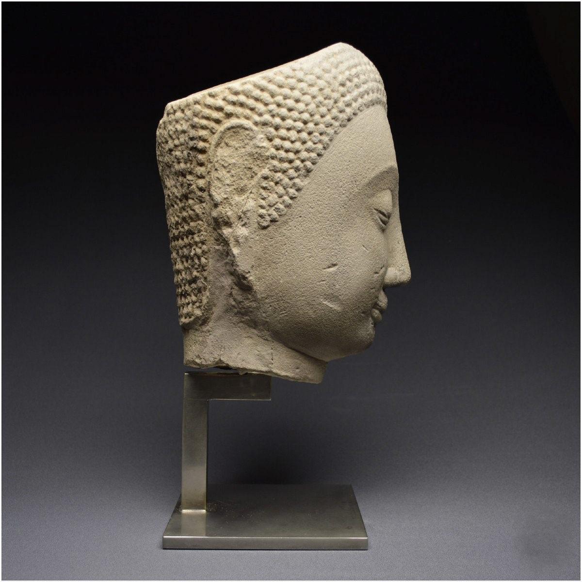 Grande tête de Bouddha Shakyamuni en grès  
Thaïlande (anciennement Siam), Royaume d'Ayutthaya
17ème siècle
16 1/2 pouces sur pied,  11 1/3 sans
Collection privée, France.

Le visage est ovale et présente de grandes arcades sourcilières curvilignes