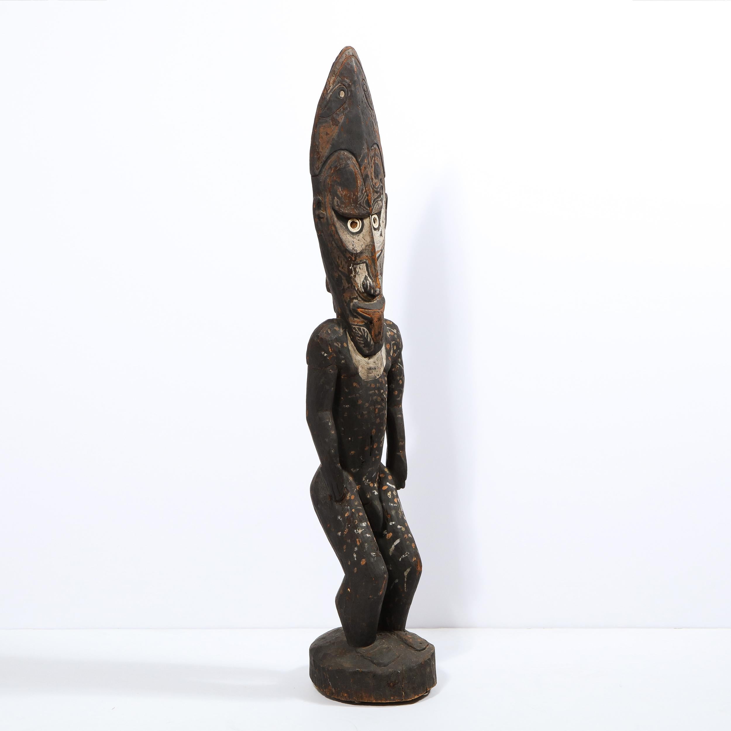 Realized in Papua New Guinea circa 1960, this is a striking example of tribal sculptures from the region. The oversized ovoid head has inset circular eyes rendered in white pigment. Traces of organic pigment have been painted over the surface of the