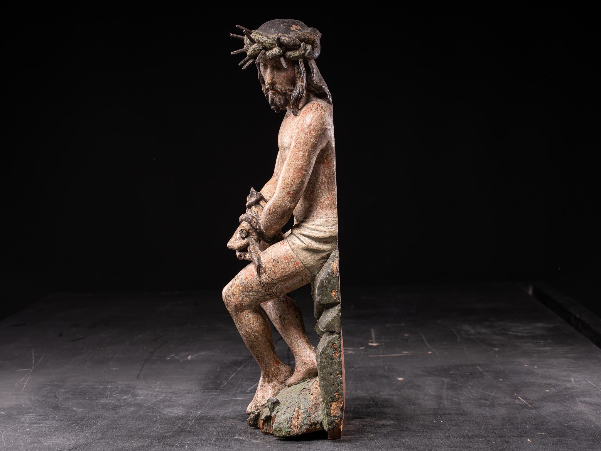 Late 16th C Polychromed wooden sculpture of Christ with the Crown of Thorns on the cold stone with his hands crossed in his lap, the moment after the calvary and immediately before the crucifixion. Soft and tender face, the eyes downcast, His whole