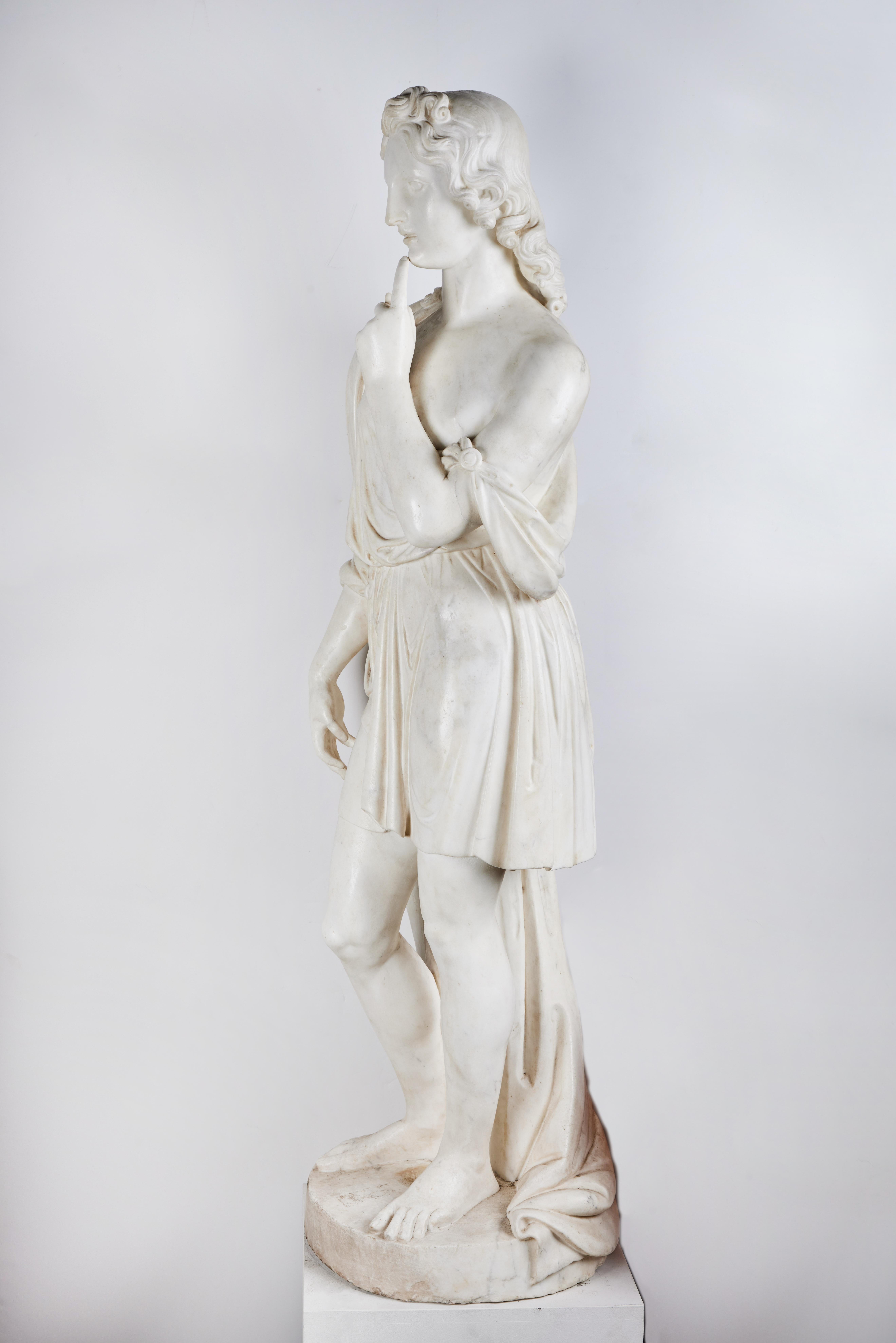 A beautifully hand carved, full size Carrara marble figure of a boy. The robe is elegantly draped with clasps.