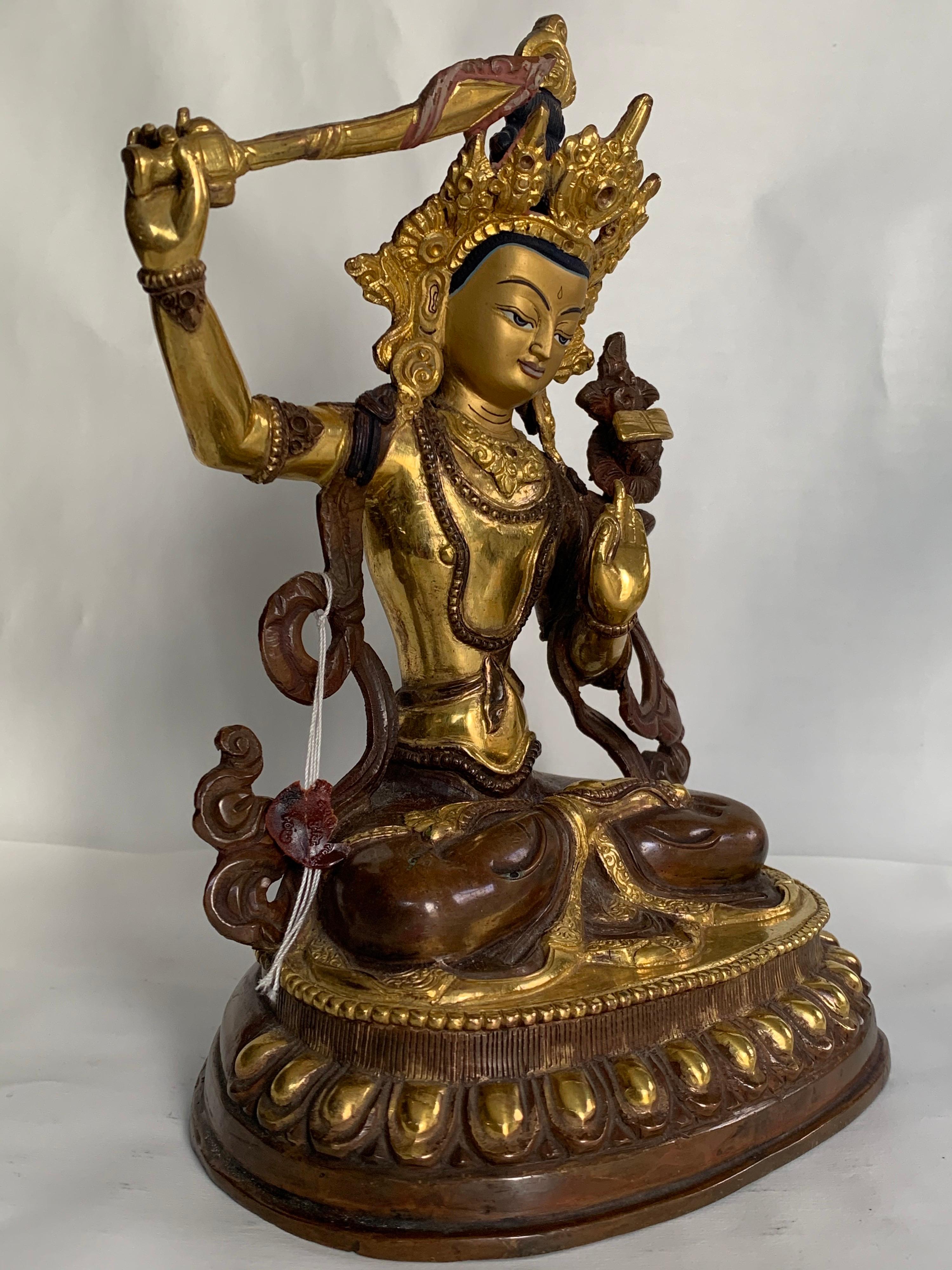 This statue is handcrafted by lost wax process which is one of the ancient process of metal craft. Manjushree is seated on lotus with one hand holding a sword which is believed to cut down ignorance. 24K gold plating is done on copper body. 
A long