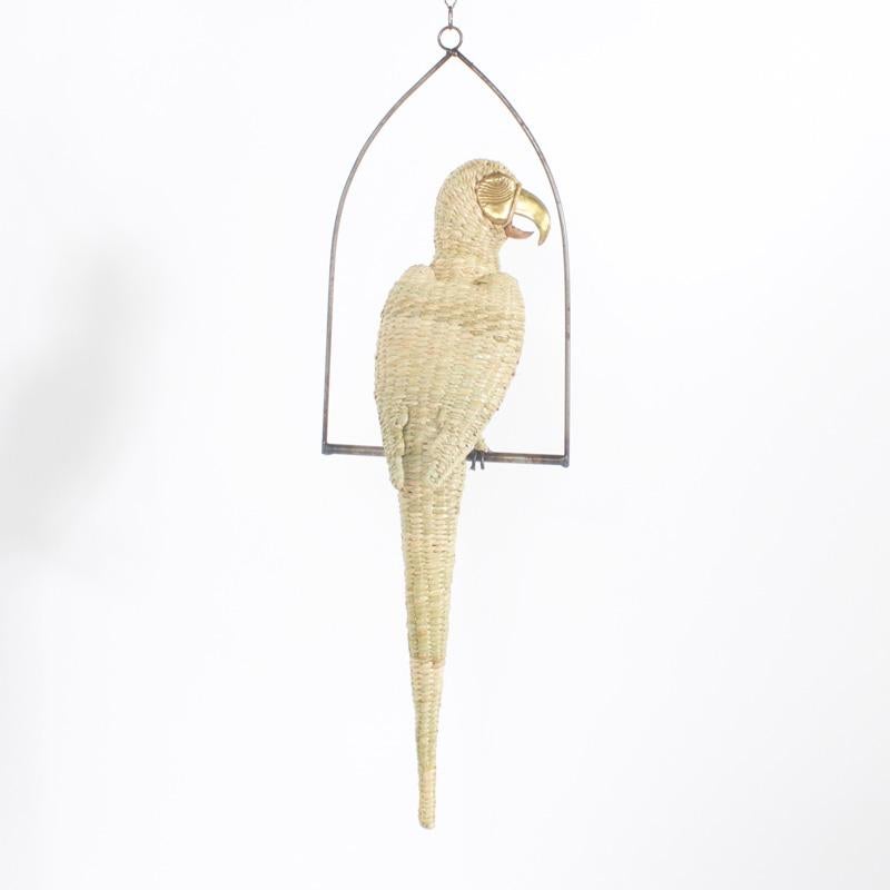 Amusing midcentury Mario Torres wicker parrot perched on a metal swing. Having a brass face and beak he appears to be saying Polly wants a cracker.