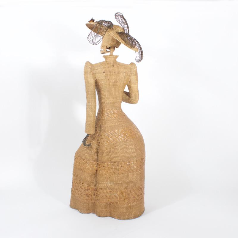 Amusing and macabre life size midcentury Mario Torres woven wicker sculpture of a woman in Edwardian attire. Having copper flowers and metal feathers on her hat and skeletal hands, one holding an umbrella. This unusual sculpture is composed of a