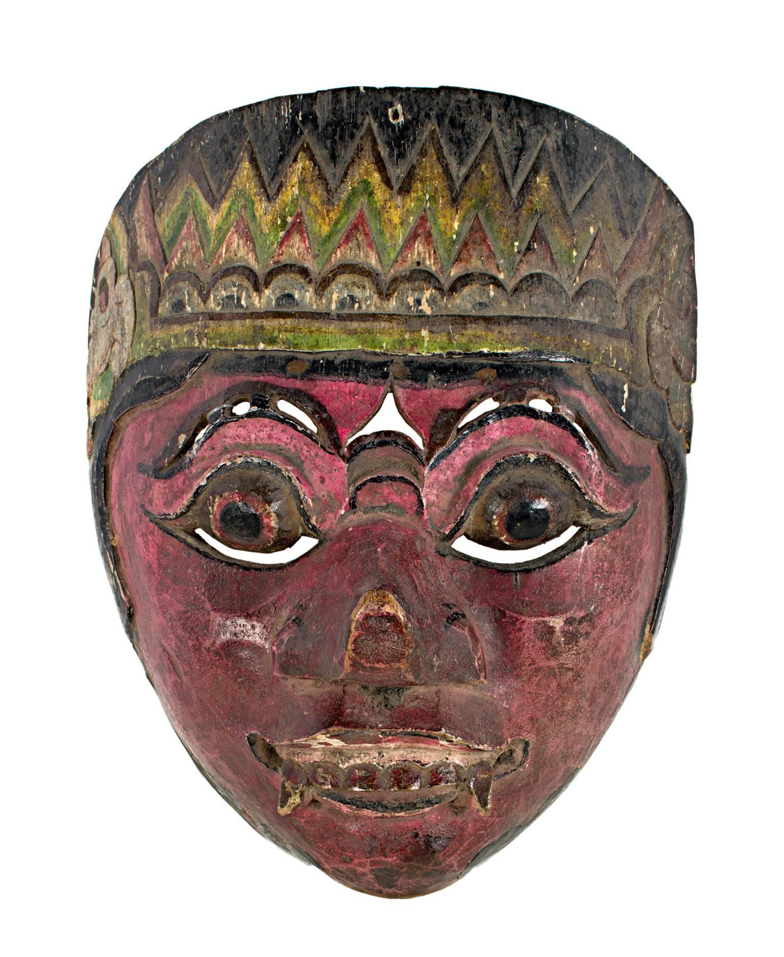 Ce masque, qui présente un visage aux yeux ronds, des crocs et un visage rouge betterave, a été créé par un artiste indonésien inconnu. Il mesure environ 7 1/2