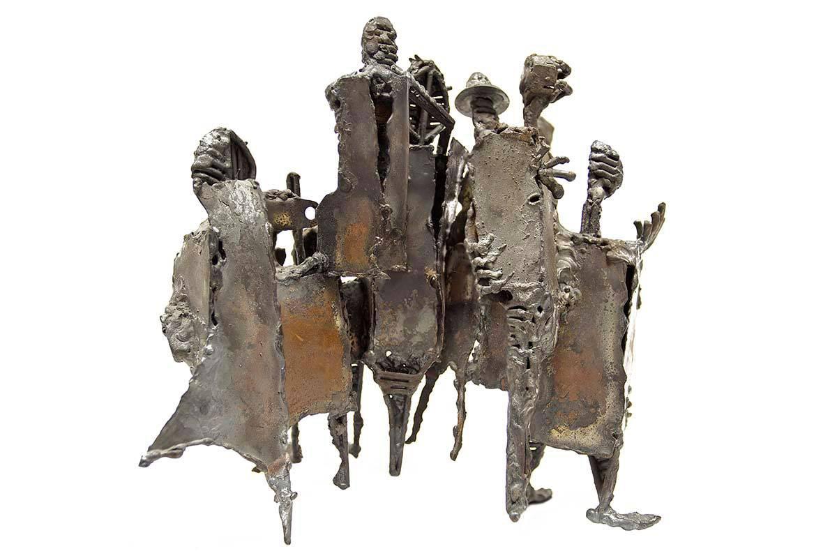 In dieser Bronzeskulptur hat der Künstler (unbekannt) eine Gruppe von Figuren zu einem einheitlichen Werk zusammengeschweißt. Diese Figuren nehmen sowohl tierische als auch menschliche Züge an, was sich in der Form ihrer Körper und Gesichter