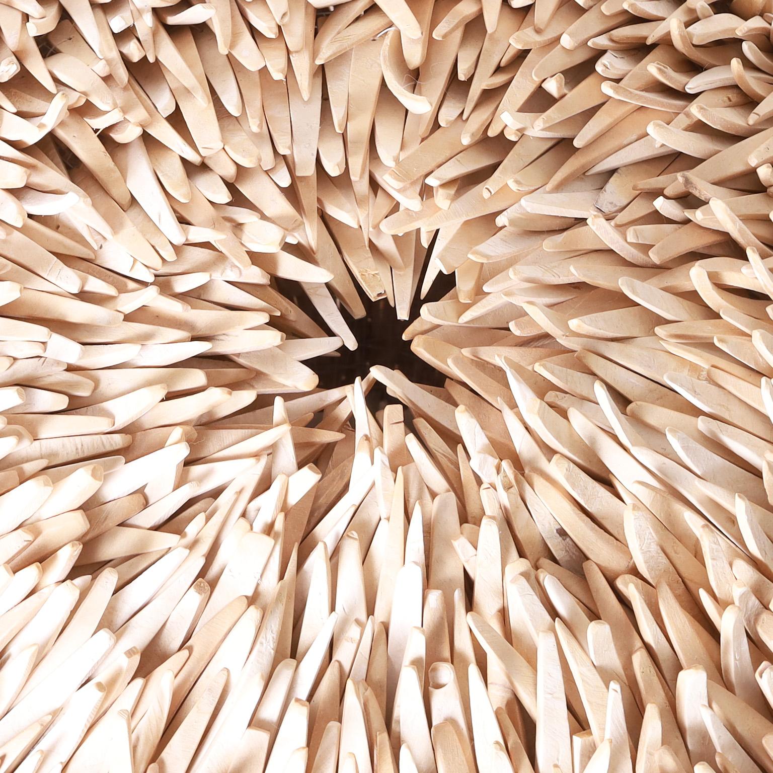 Striking sea urchin form lighted sculpture ambitiously crafted with hundreds of wood spines fixed to a sturdy metal frame.