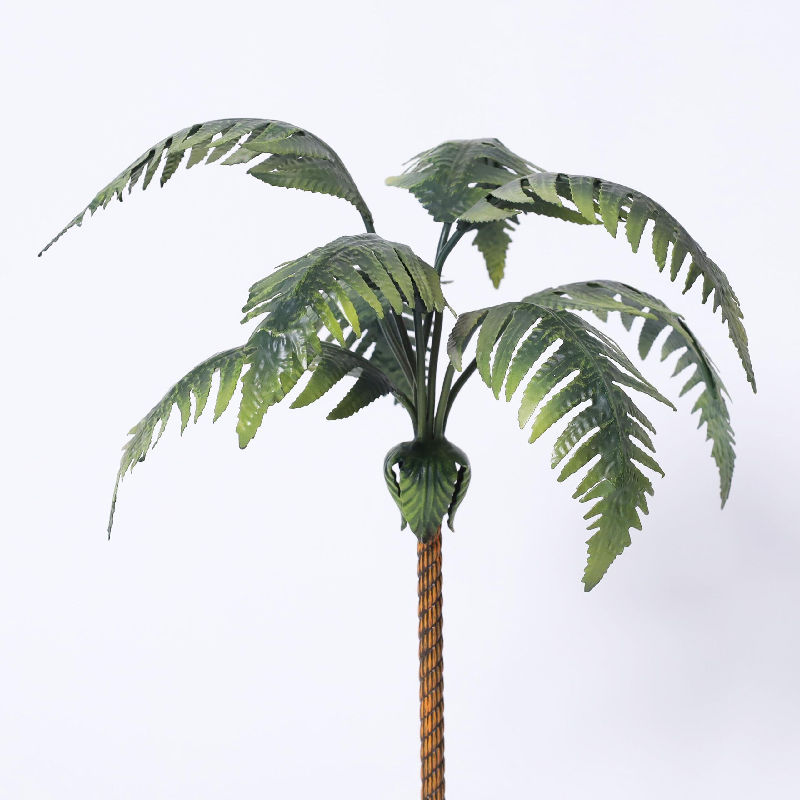 Chic vintage Italian palm tree object of art having tole leaves on a brass trunk in a classical porcelain planter with quartz stones.