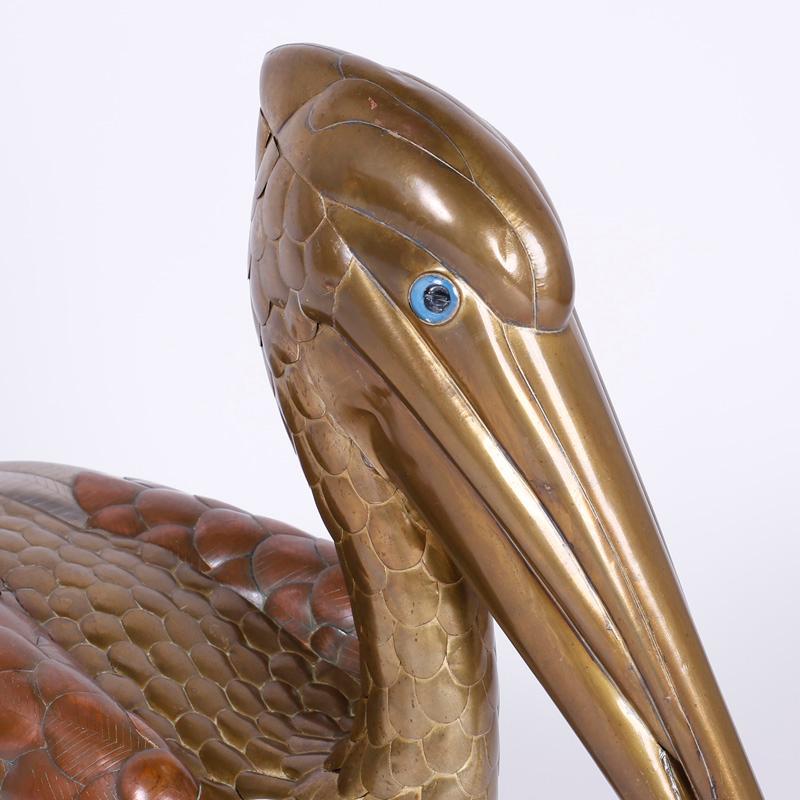 Amusing mixed metal pelican sculpture crafted in brass, copper, and silvered metal in a distinctive and captivating composition that combines technique with attitude.