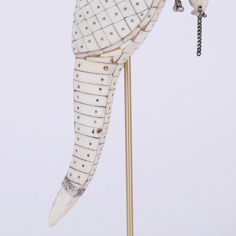 Intriguing Anglo-Indian Parrot sculpture skillfully crafted with a mosaic of ox bone fragments. This stylish bird is sporting hand-hammered silver jewelry including a nose ring, all this presented on a brass rod and Lucite base.