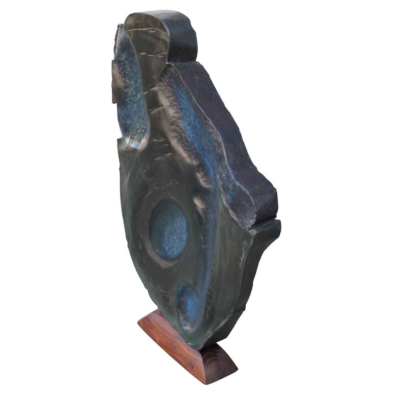 Modern abstract organic sculpture that consists of metal and a wooden base. 
The piece is signed 