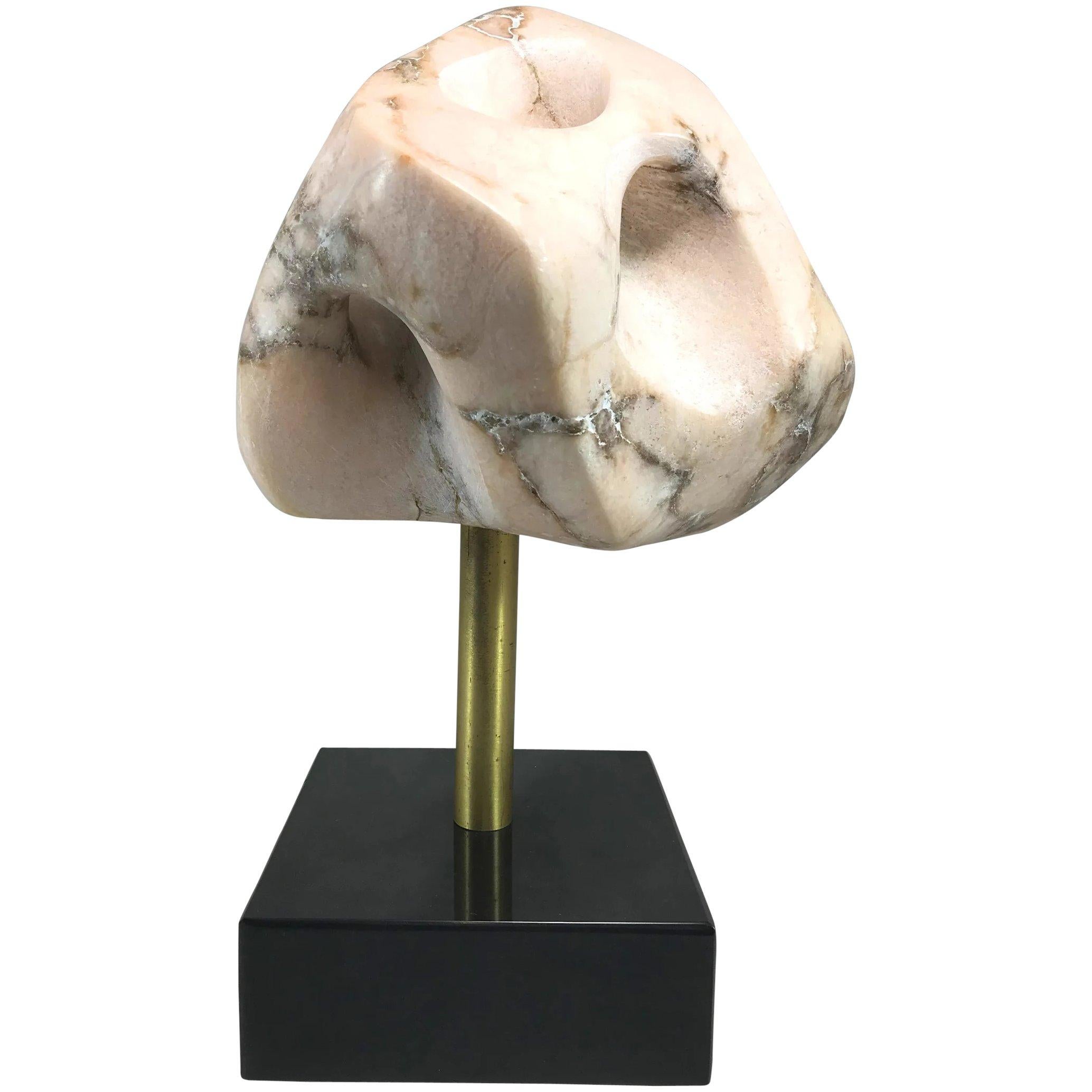A fine modernist abstract variegated marble sculpture with hints of rose or pink in the stone, contrasted with dark veining, mounted with a brass rod on a black polished stone plinth, unsigned, dating to the 20th century. Some slight yellow