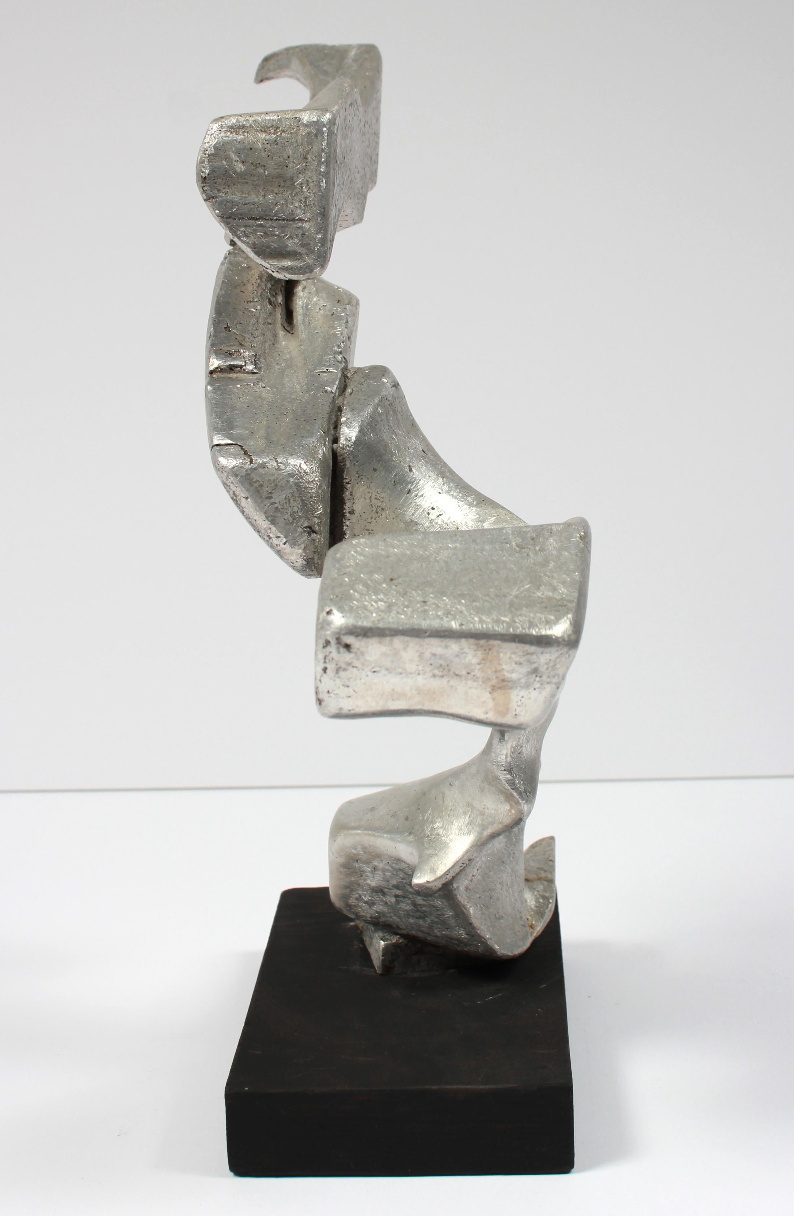 This late 20th century amorphic sculpture made with sculpting medium and metallic paint on a wood base is unsigned.  Purchased from a collector and part of a larger body of sculptural work.