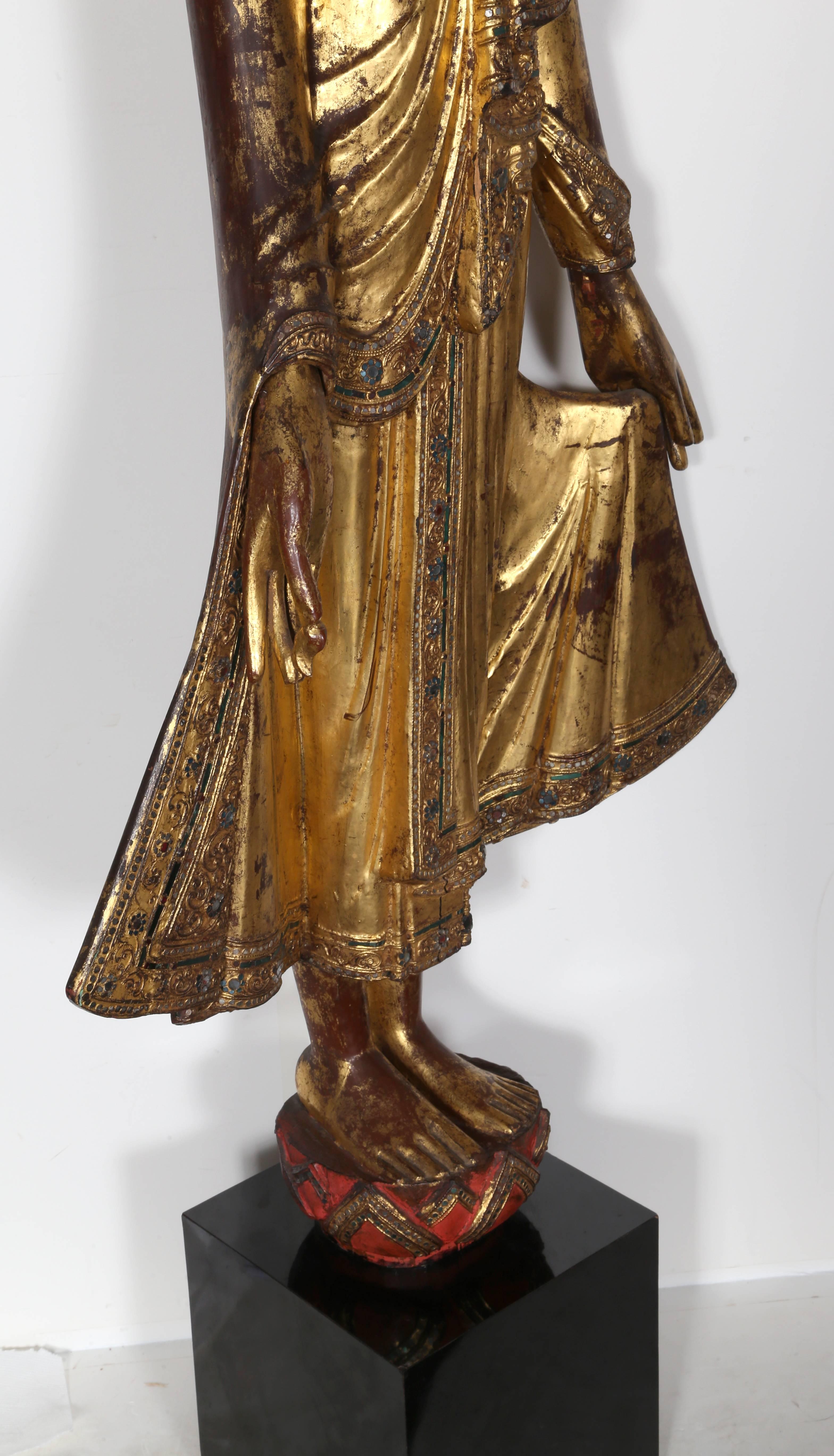 Myanmar (Burma) Mandalay Standing Buddha
Title:	Standing Buddha 
Medium: Painted hand-carved wood sculpture with gold and jewel detailing
Size: 60 x 26 x 8 in. (152.4 x 66.04 x 20.32 cm)