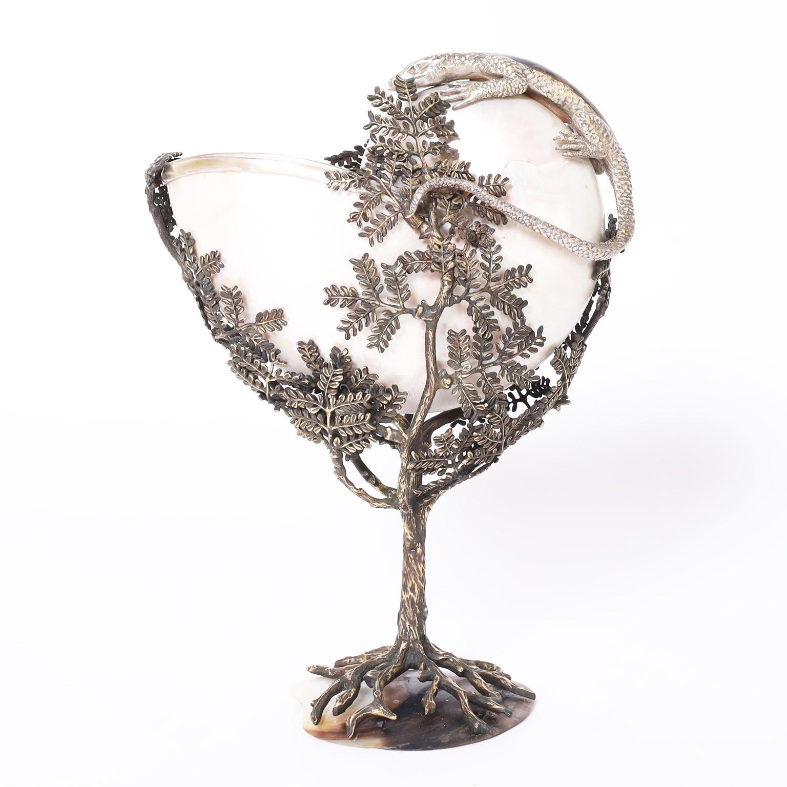 Intriguing vintage object of art with an eccentric composition having an organic nautilus shell in a cast metal tree on a penshell base featuring a silver plate lizard with a tortoise shell back.