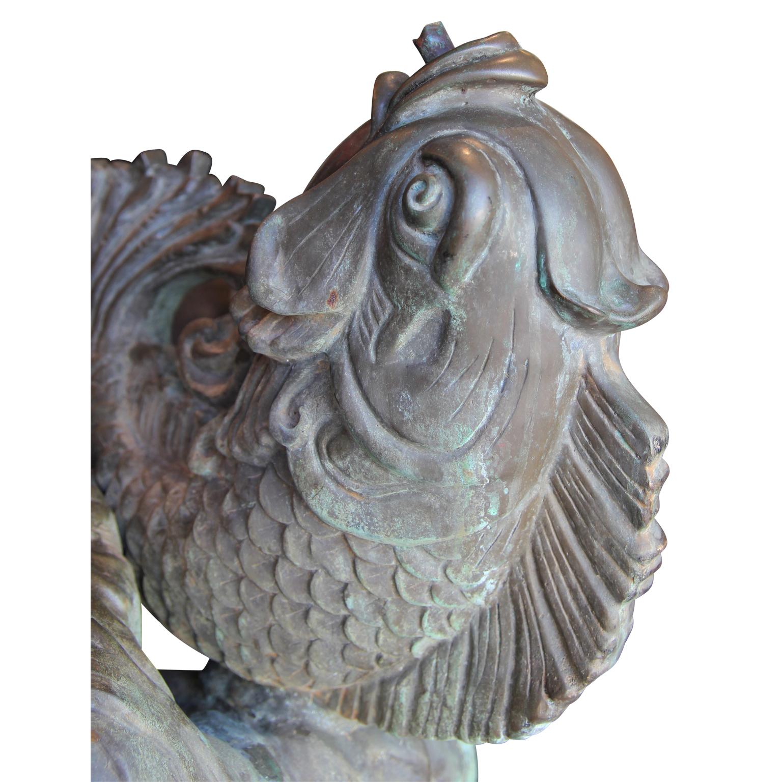 Bronze fountain sculpture of Cupid hold a fish. This beautiful bronze sculpture features intricate details and has a nice natural patina.