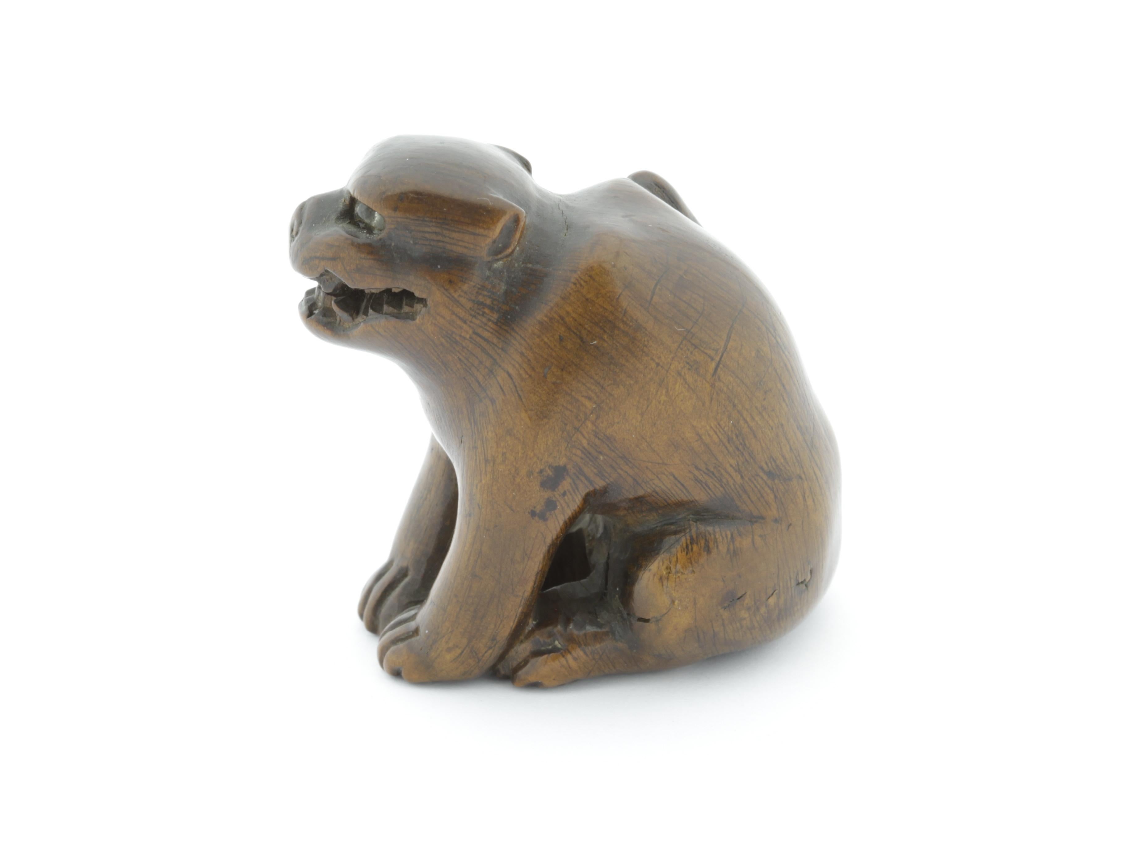 This growling dog netsuke is made entirely out of wood, with glass eyes. As glass was a rare material in 19th century Japan, it can be assumed they are a later addition, perhaps as part of a restoration. In Japanese culture, the dog is the eleventh