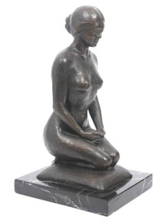 Figure de femme nue agenouillée sur le coussin