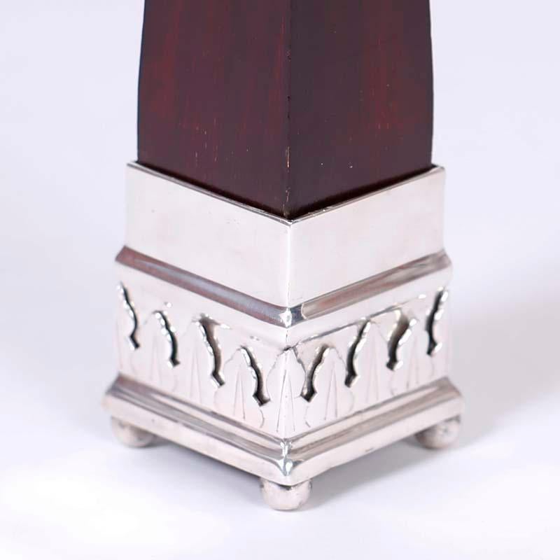 Standout pair of Anglo Indian obelisks with classic form crafted in mahogany and with silver plate bases with floral designs and ball feet. Signed on the bottom S P 2001.