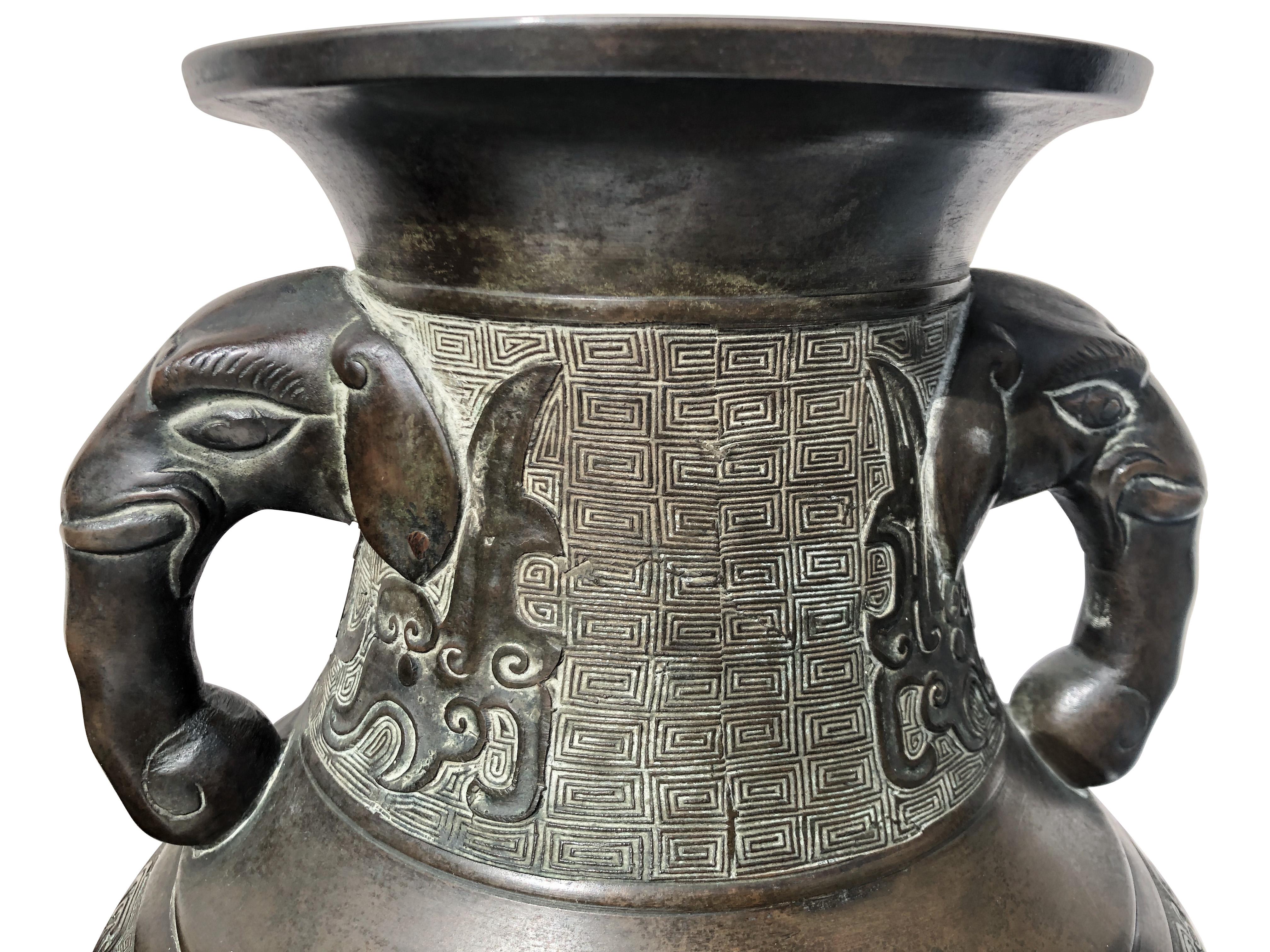 Paire de grands vases japonais en bronze de la fin du 19ème siècle avec des poignées en forme de têtes d'éléphants et des détails en patine brun foncé et verte comme le montrent les photos.
