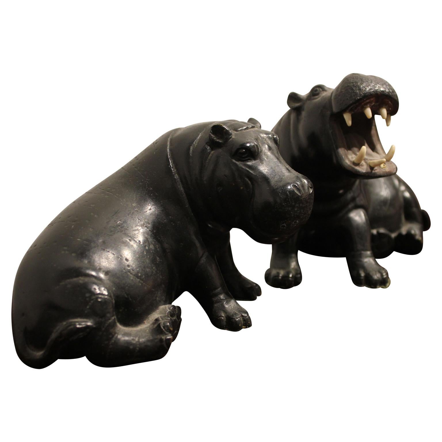 Pair of incredibly detailed brass hippo sculptures. The hippo with an open mouth has highly realistic teeth. Sold as a set of 2. 

Open Mouth Hippo Dimensions: H 4.75 in. x W 6 in. D 4 in.
Closed Mouth Hippo Dimensions: H 4 in. x W 6 in. x D 4.25 in