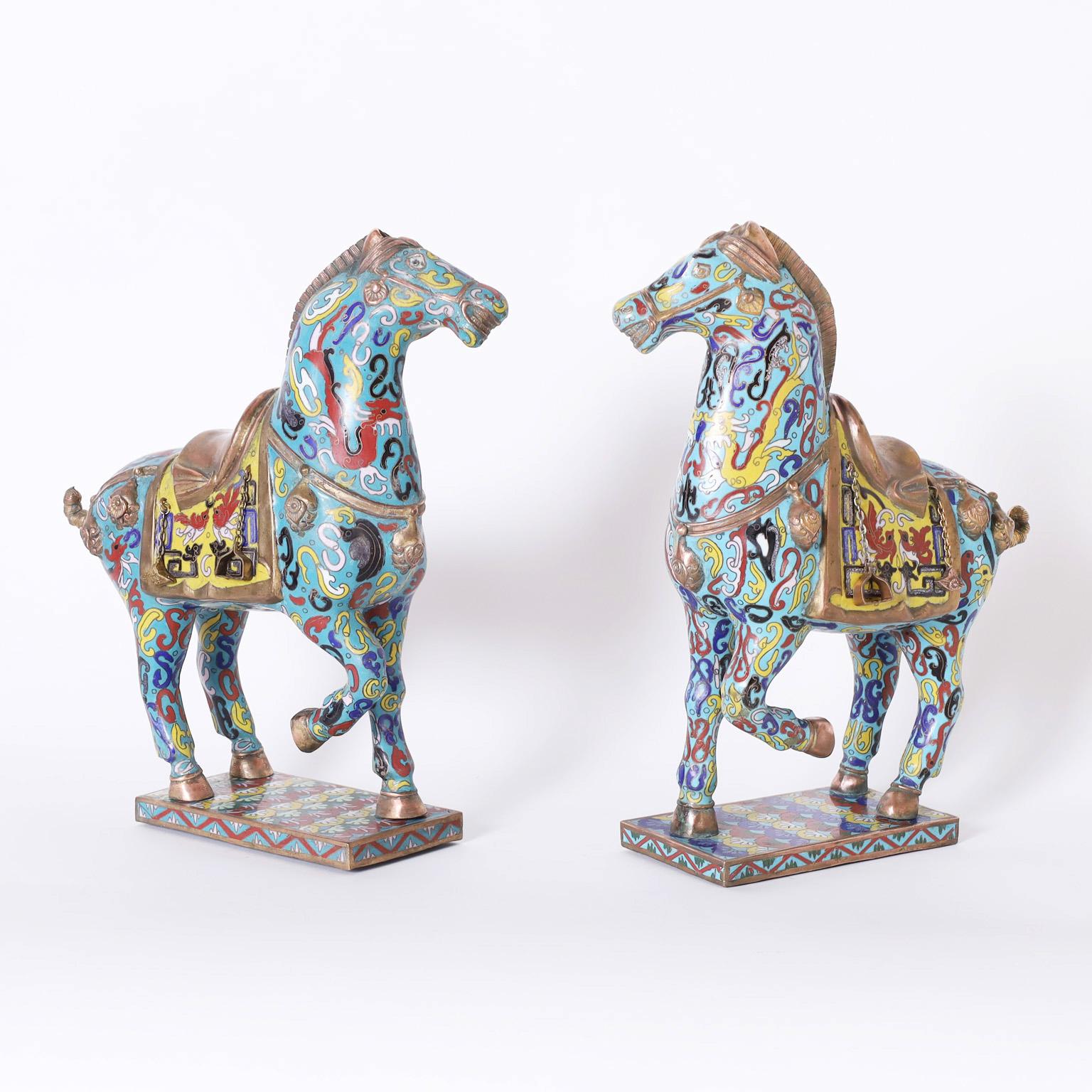 Vintage pair of Chinese cloisonné horses with a Tang dynasty form decorated with colorful symbolic references on an alluring blue background.